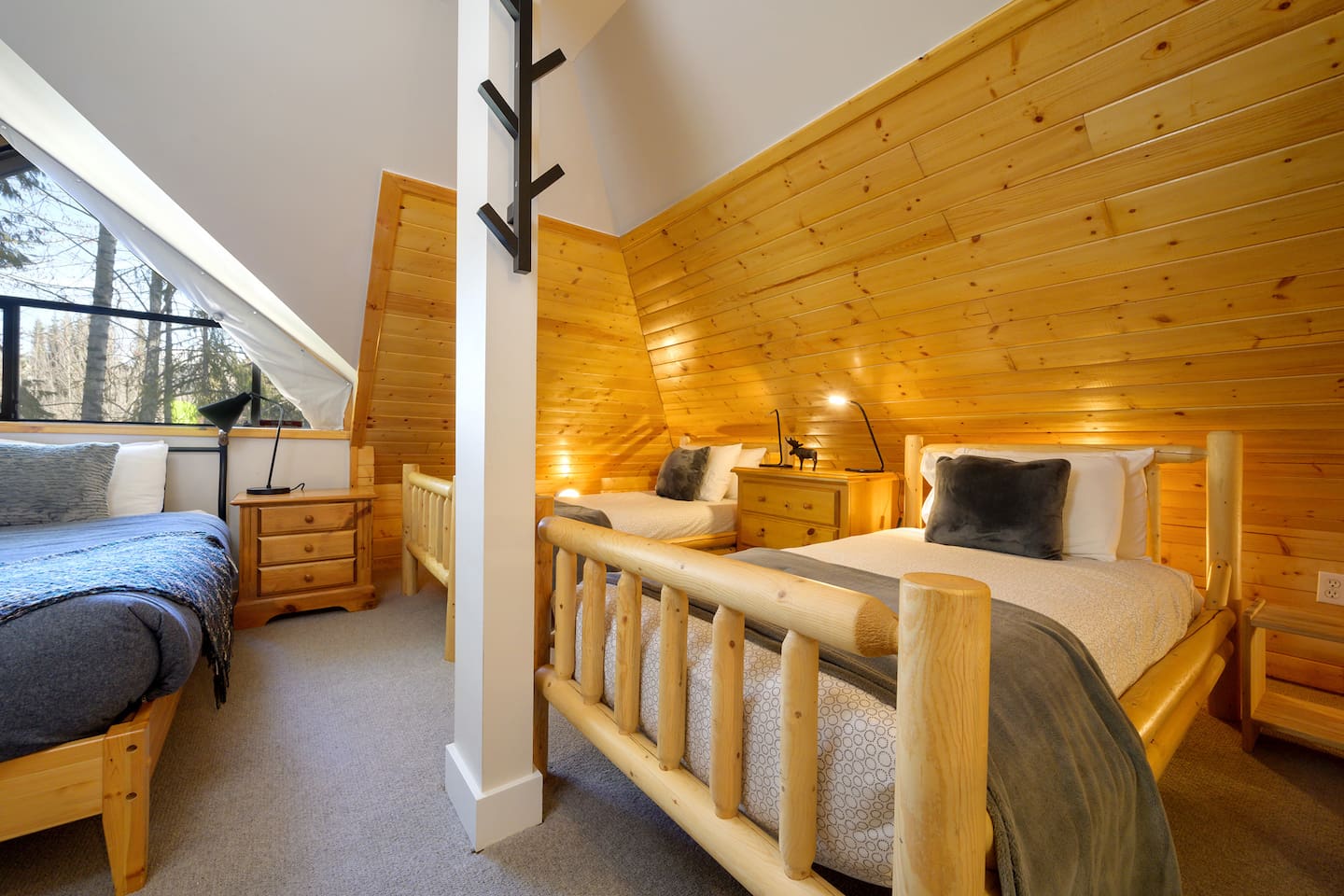 Top floor bedroom includes two hand carved twin beds that flank the queen bed sitting right below  a peaked window overlooking Blackcomb Mountain. A modular couch & TV lounge + ensuite bathroom with shower complete this top floor oasis.  