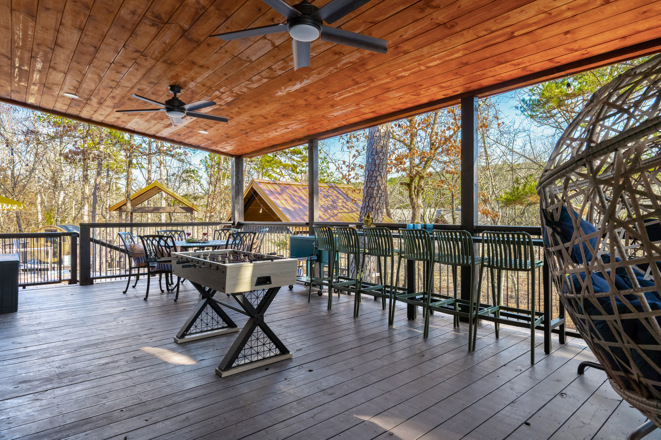 Covered Porch: Unwind with nature views, foosball, and comfy seating for your best outdoor moments!