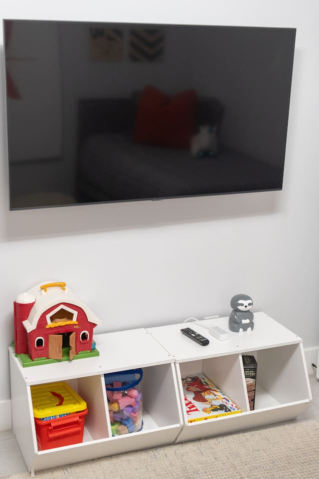 Entertainment corner with wall-mounted TV and toy storage below.

