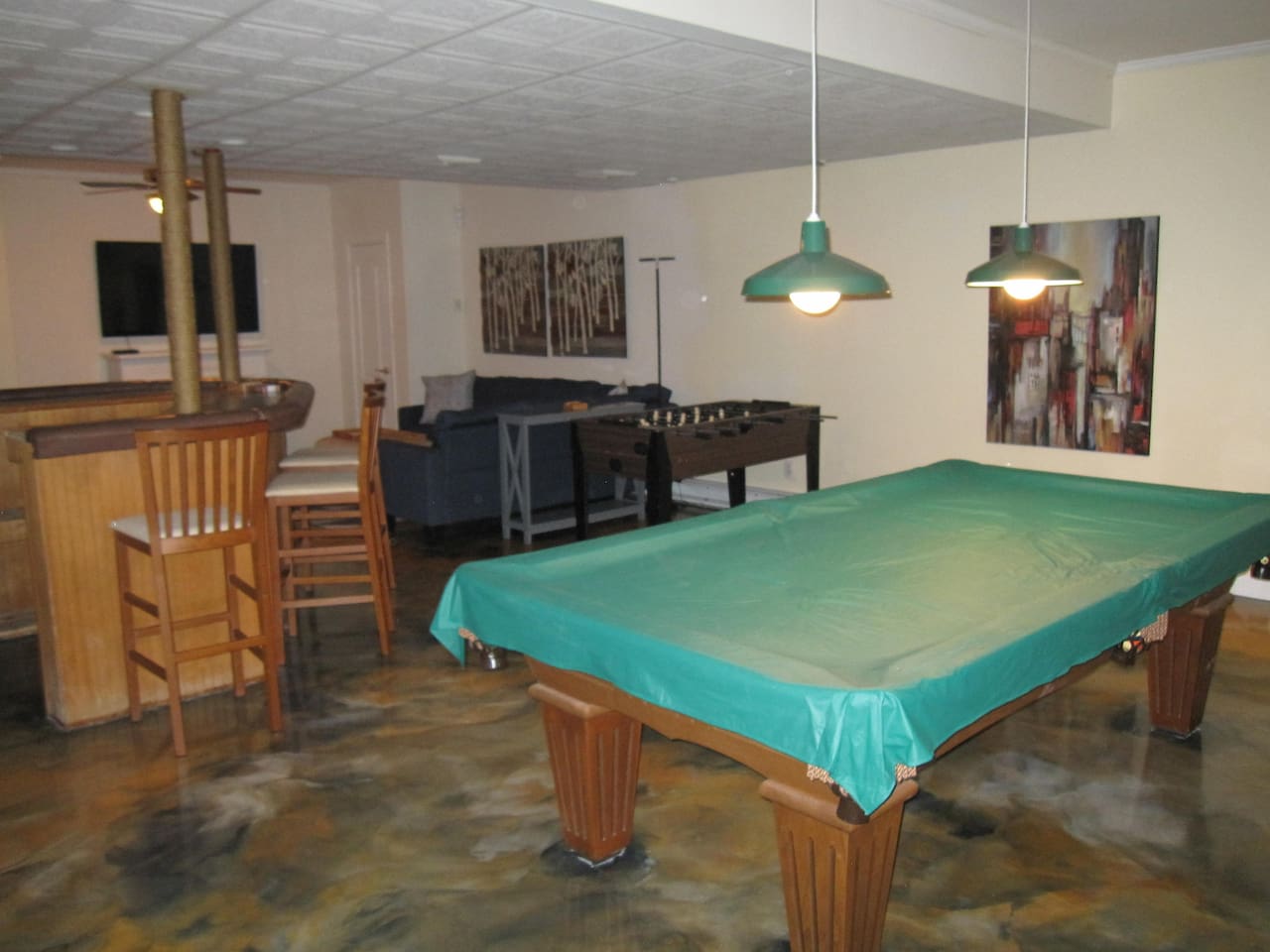 Regulation size pool table and a foosball table as well as a TV and a bar area. This floor also has a full bathroom with shower.