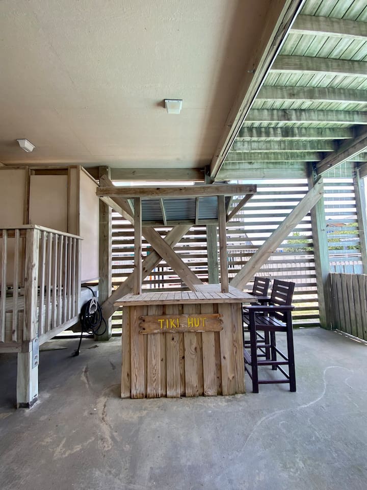 Poolside tiki hut with seating and charm.
