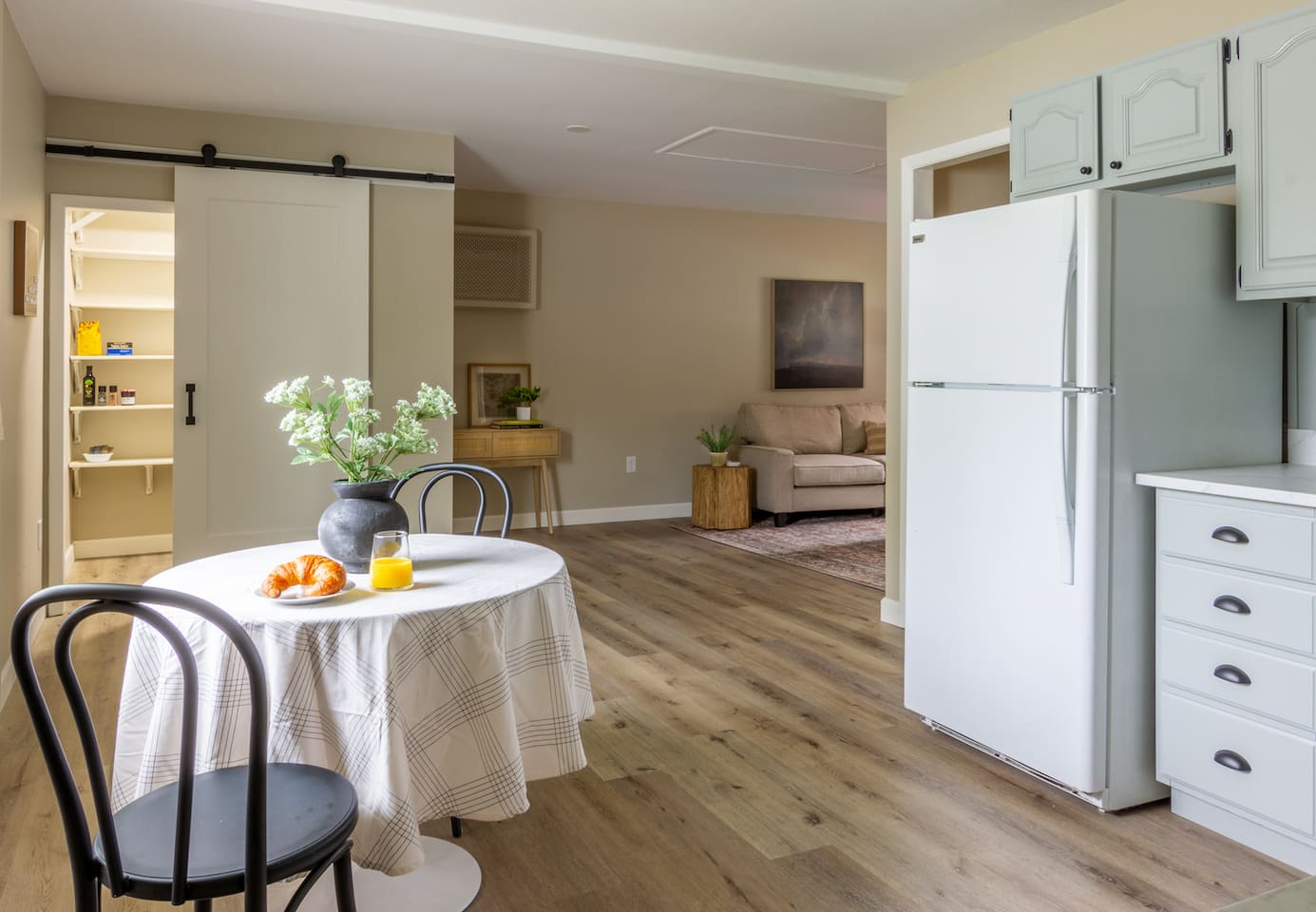 An open flow from the dining nook to the living room, with a barn door pantry for extra storage.