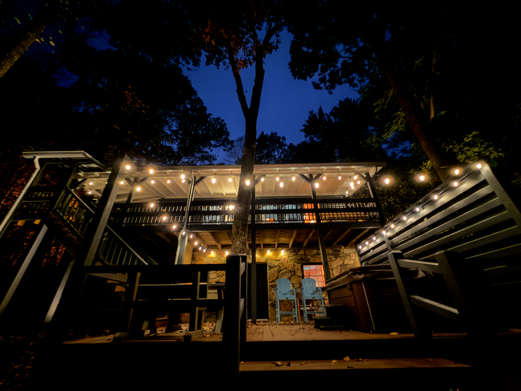 Deck lit with string lights at night.