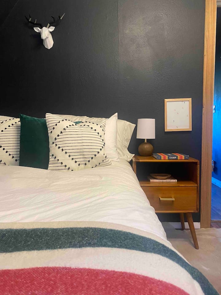 Downstairs Queen bed. With hanging rack and nightstand for your things. 