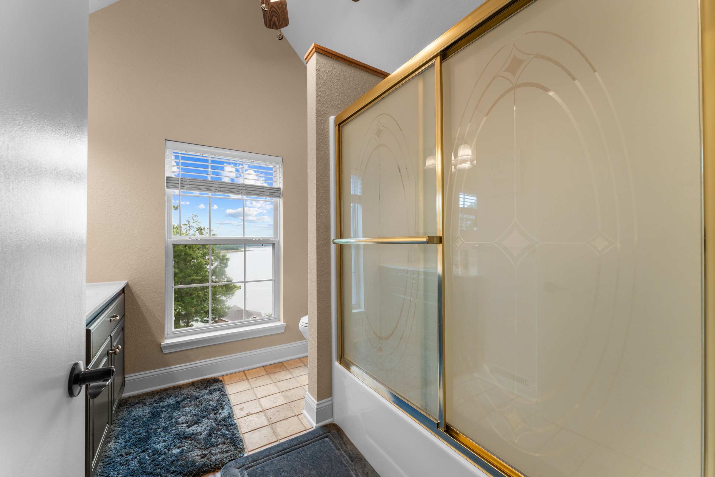 Upstairs full bathroom with tub-shower and a lake view. The window frames the water while you get ready.