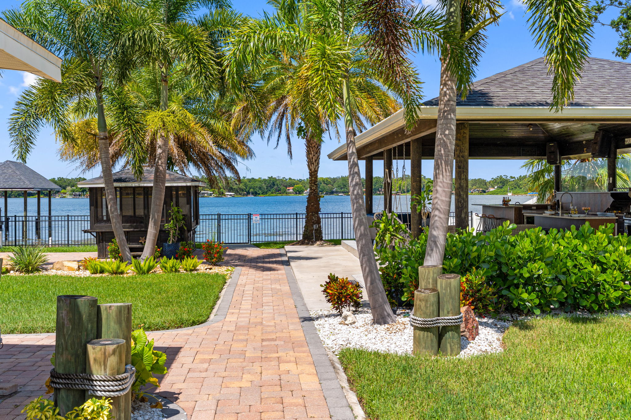 Blend indoor comfort with outdoor charm in this covered kitchen and seating area, set against a backdrop of sparkling water views.