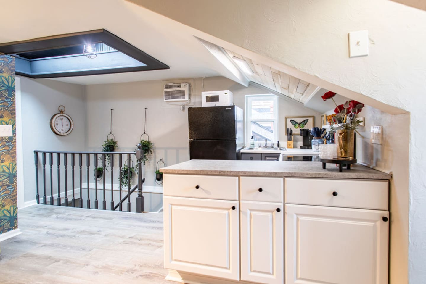 Step into a world where vintage flair meets 70's hippie chic at the top of these stairs. This open-floor plan 1-bedroom, 1-bathroom apartment boasts a kitchen and living room space that exudes funky vibes. Immerse yourself in a stylish, eclectic atmo