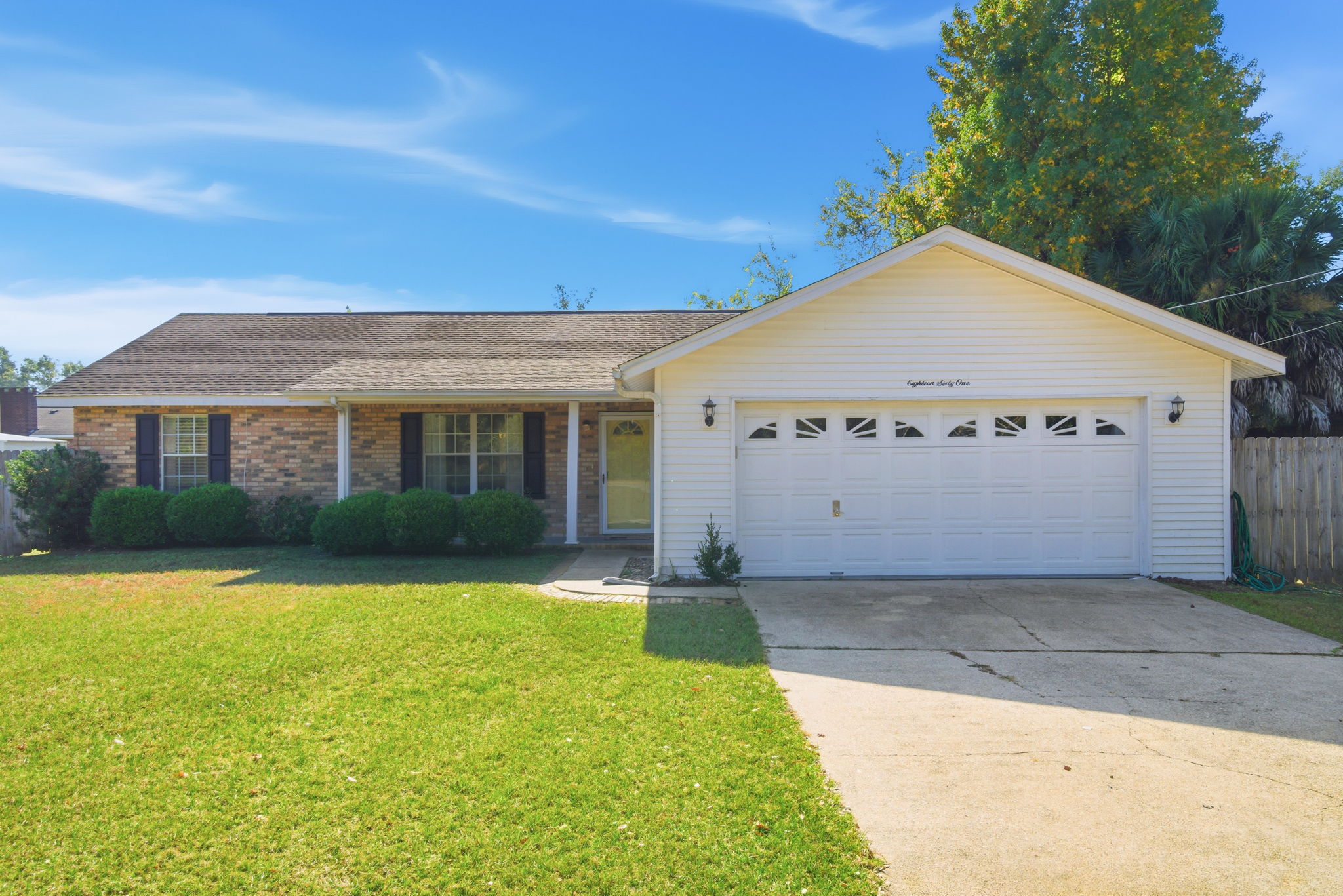 Charming curb appeal welcomes you to this cozy home with a spacious driveway, manicured lawn, and a classic brick-and-siding exterior.