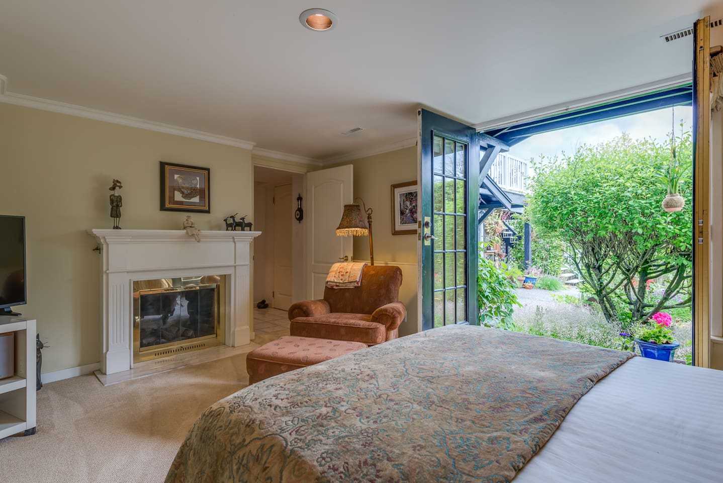 Double French doors leading to the garden and comfy reading chair and fireplace.
