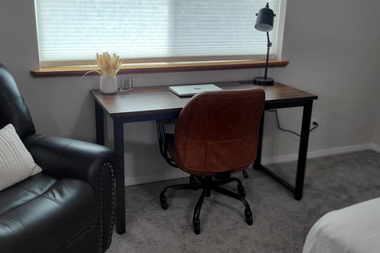 Bedroom workspace with desk, lamp, and chair for work trips or extended visits.