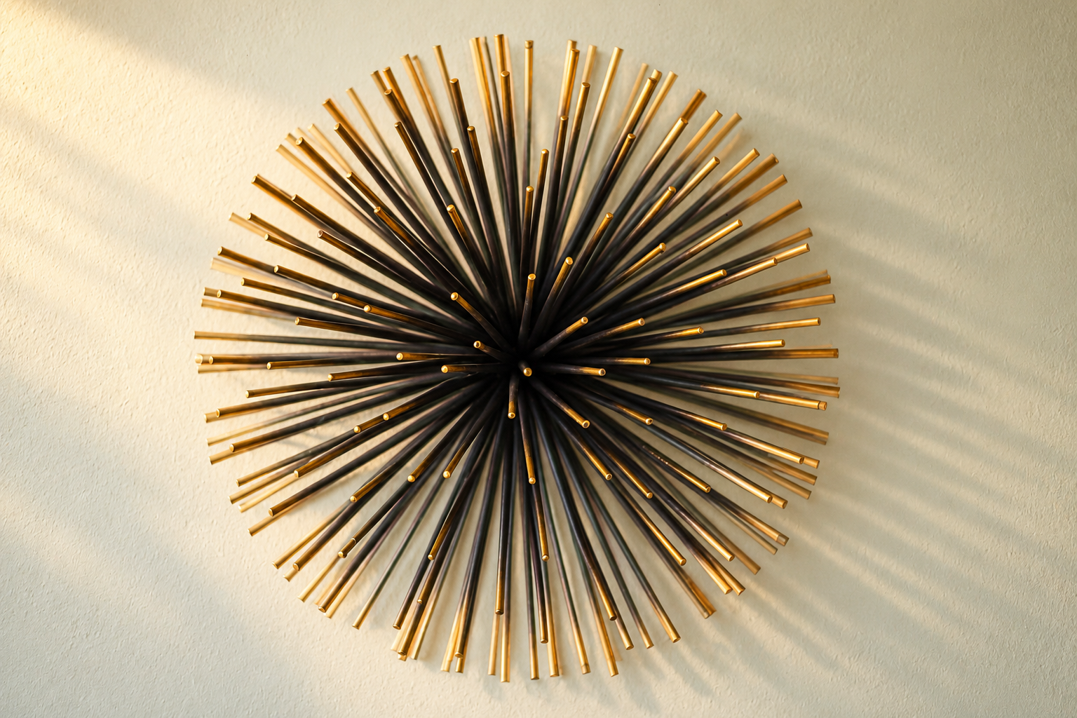 A sculptural sunburst wall piece brings a distinctive mid-century accent to the apartment. Black and gold-toned rods catch the warm light and cast delicate shadows, highlighting the thoughtful decorative details throughout the home.