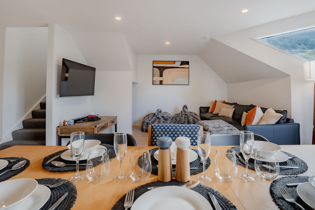 The lounge and dining area connect in one open space, giving Fernhill Mountain Escape room for shared meals, relaxed seating and easy balcony access.