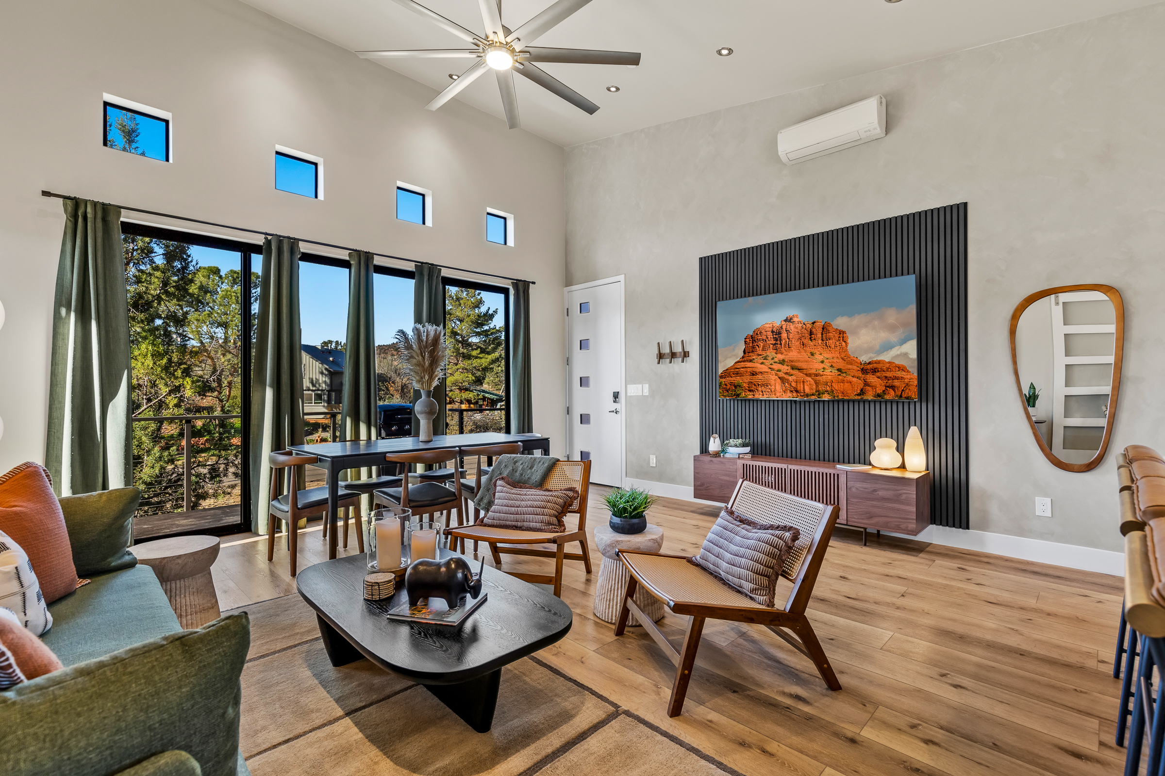 A bright, open living room with high ceilings, large windows, and comfortable seating - designed to bring in natural light and Sedona’s outdoor scenery.