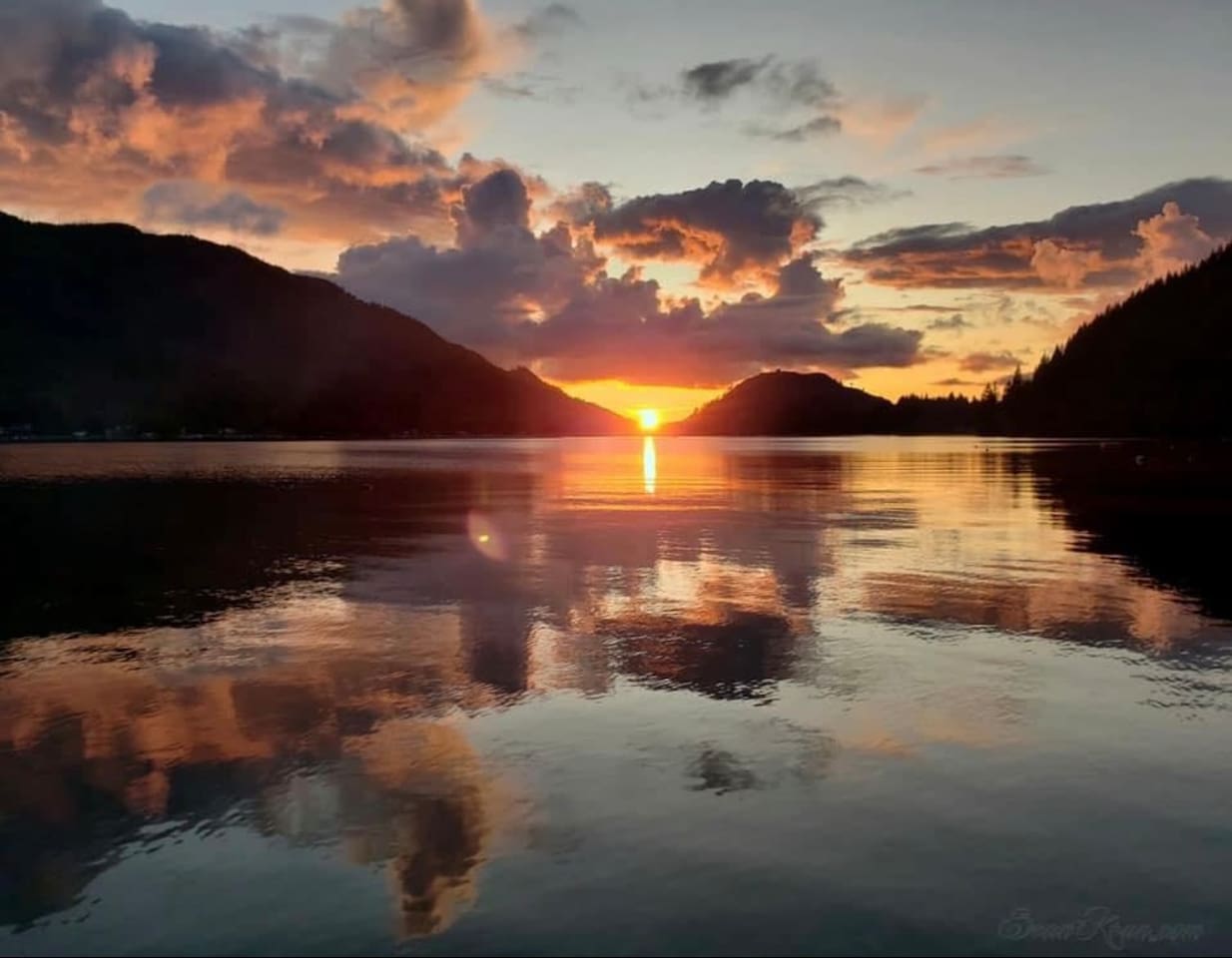 Sunset over the lake and mountains with vibrant colors.