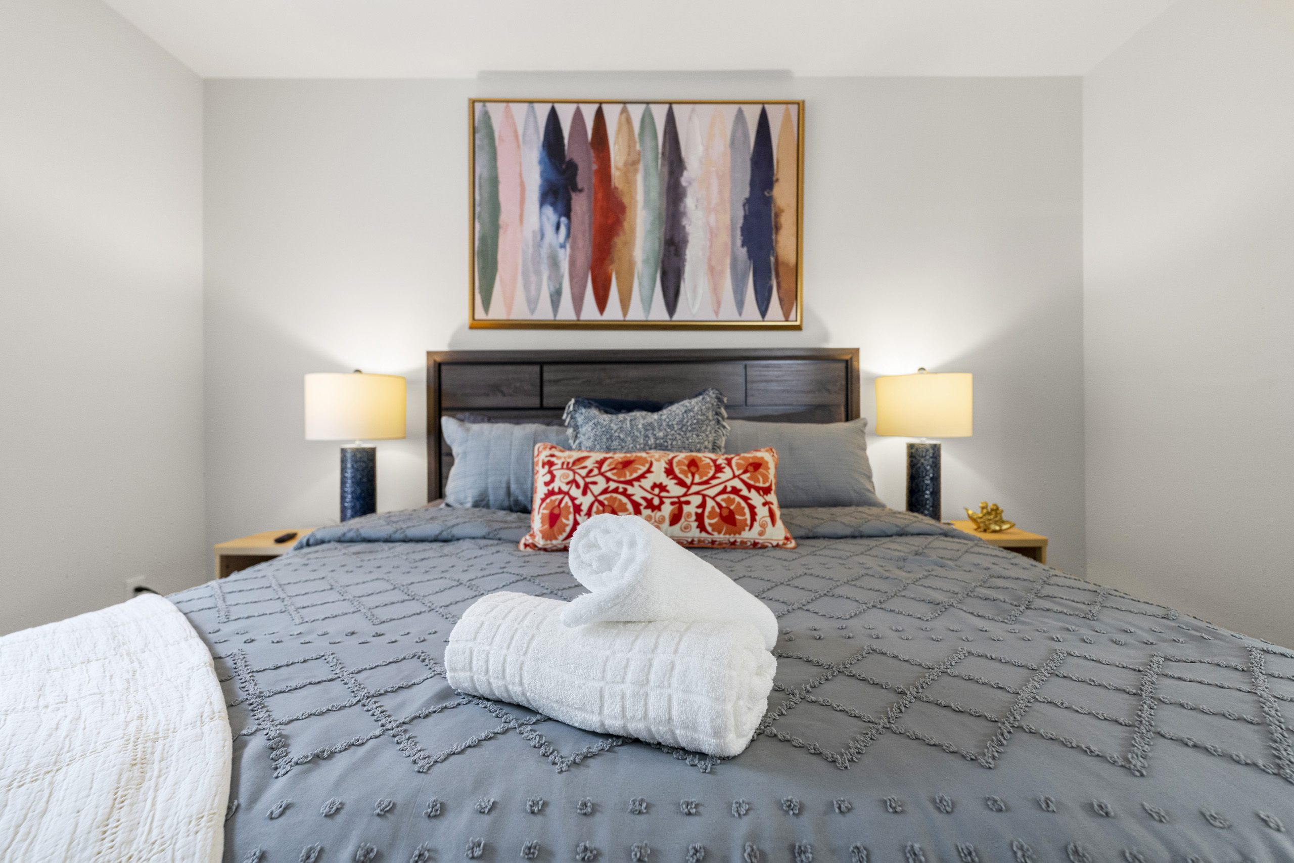 Stylish king bedroom with soft linens and warm, welcoming touches.