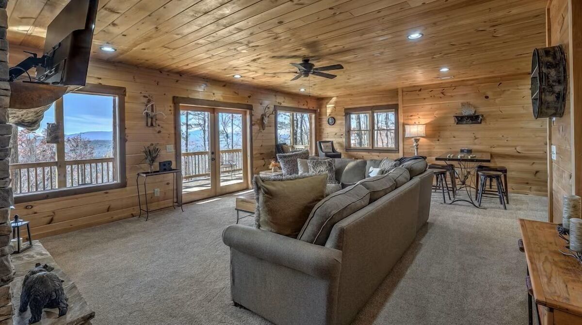 Lower-level living room with plush seating, wide windows, and a relaxed layout - perfect for movie nights or quiet downtime.