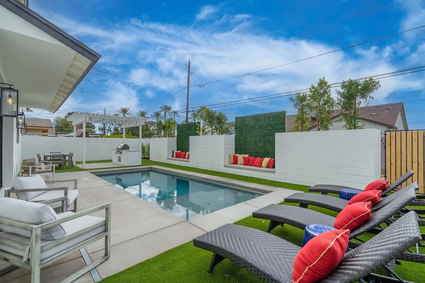 This inviting pool area features plenty of seating, a pergola with a grill, and dining tables, creating the ideal spot for relaxation and fun in the sun.