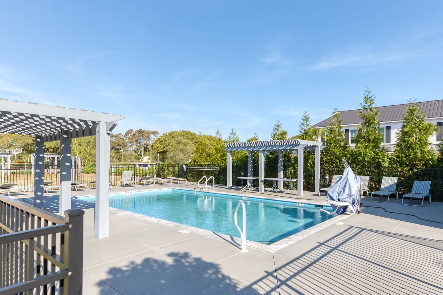 Community pool with lounge seating and pergola area