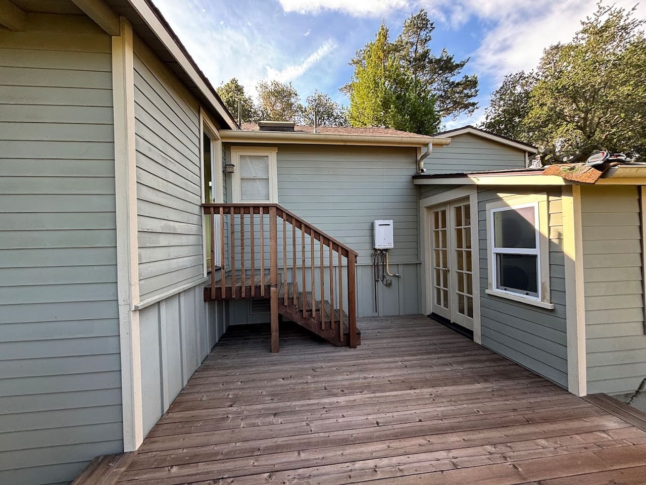 Back deck. Door on left (top of steps) leads to back bedroom, door on right leads to the laundry room.