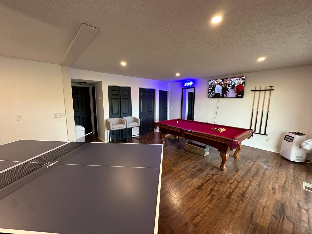 Spacious shared game room with pool table, ping pong, Connect 4, TV, board games and casual seating—perfect for relaxing or friendly competition after a day of adventure. Great for groups and families looking for fun during their stay!