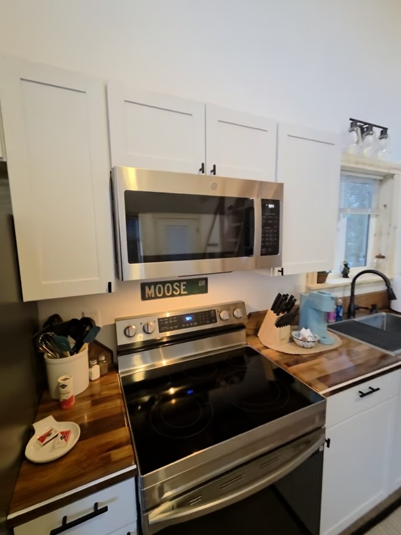Kitchen includes an electric range, refrigerator, and Keurig.