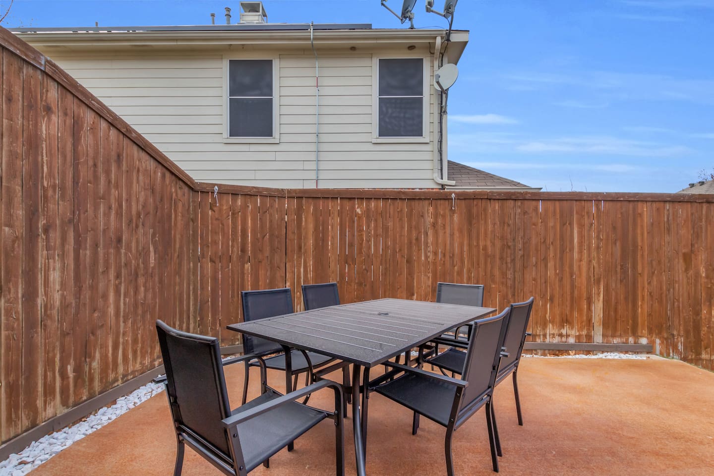 Outdoor dining area with seating for six, ideal for poolside meals, morning coffee, or evening gatherings.