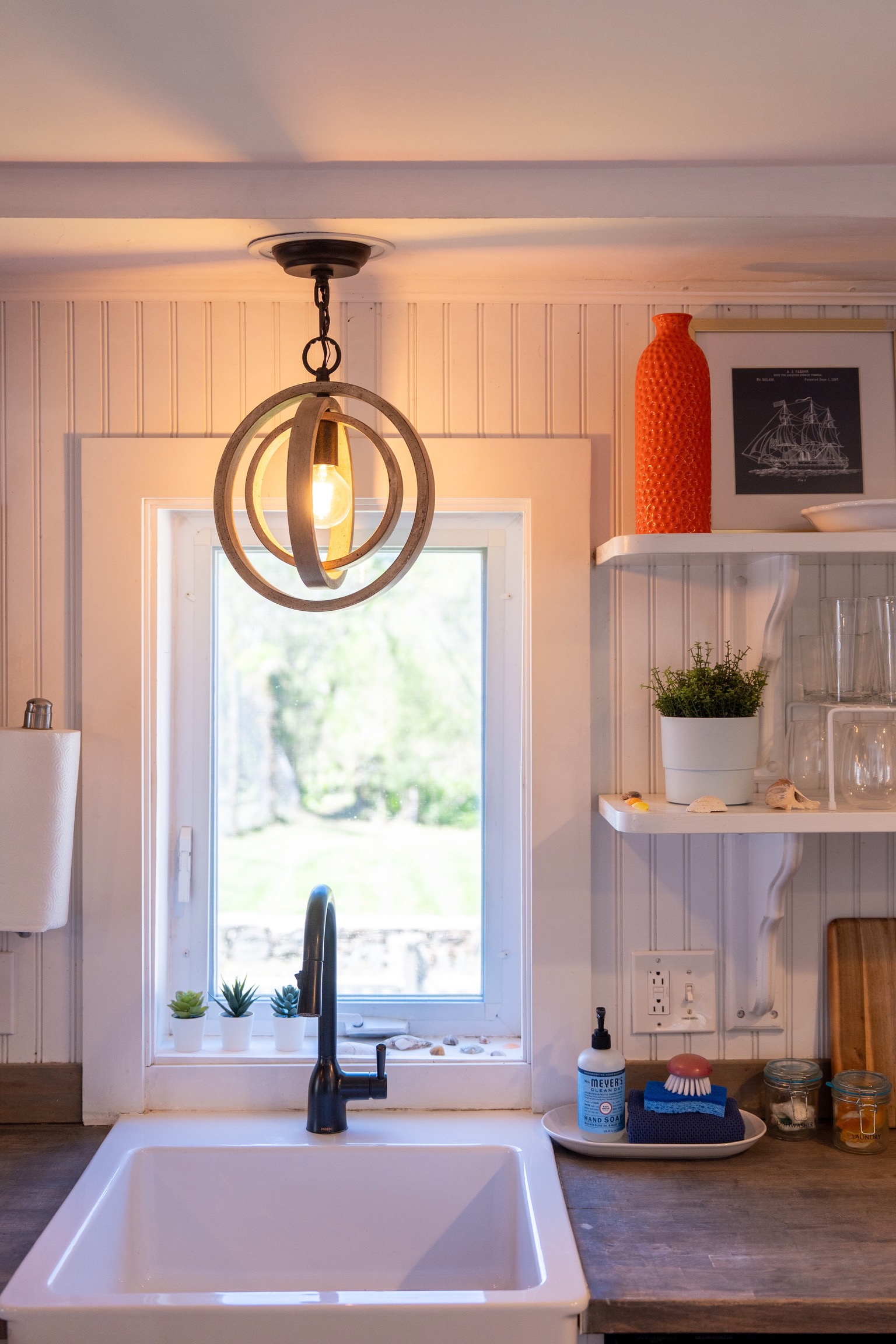 Farmhouse sink at the heart of the kitchen, with open shelving stocked with everything you may need for a comfortable stay.