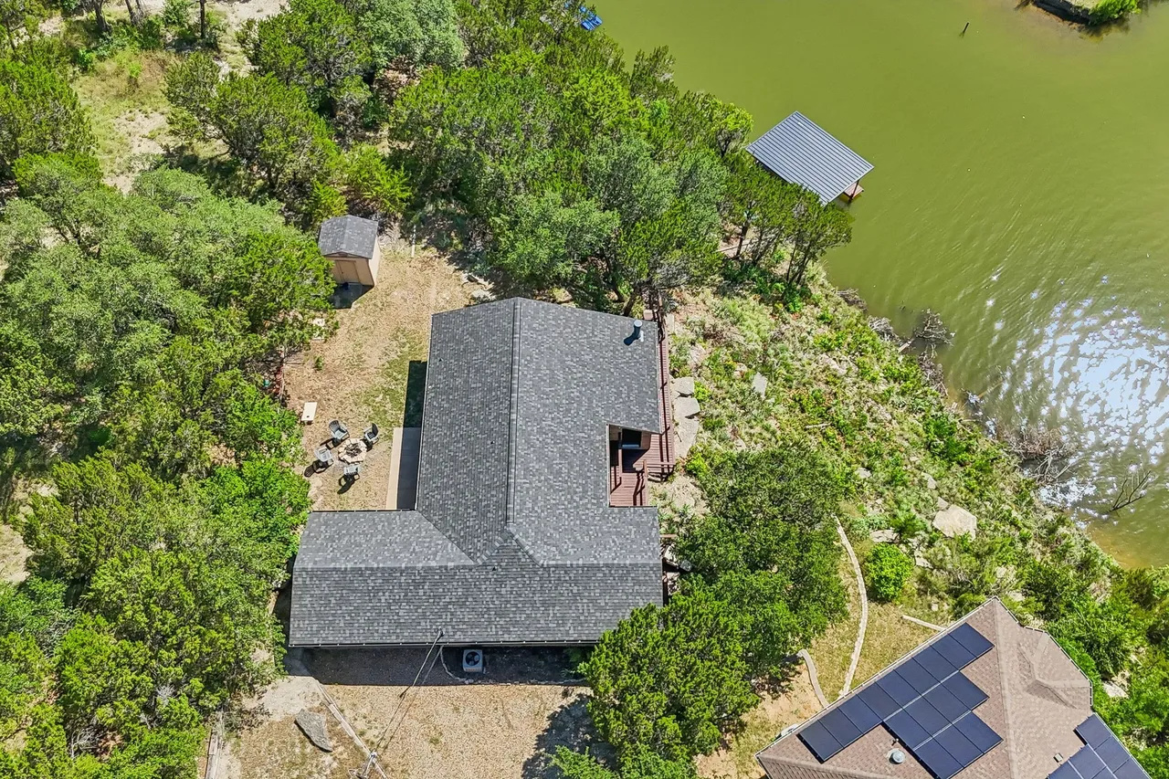 Aerial view of the roofline and waterfront setting.