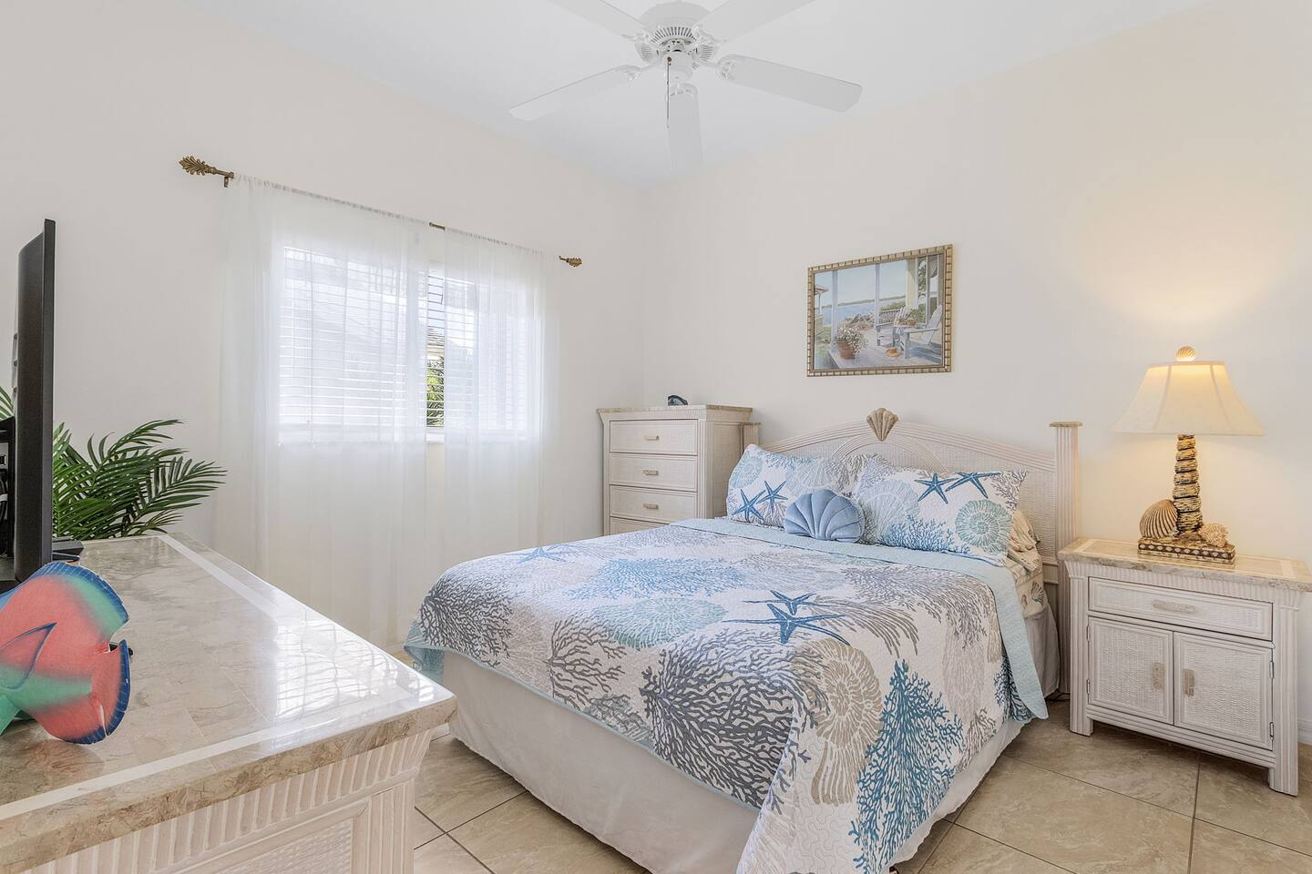 Charming 2nd Guest bedroom featuring a queen-size bed, coastal-inspired design, and a TV for added comfort!