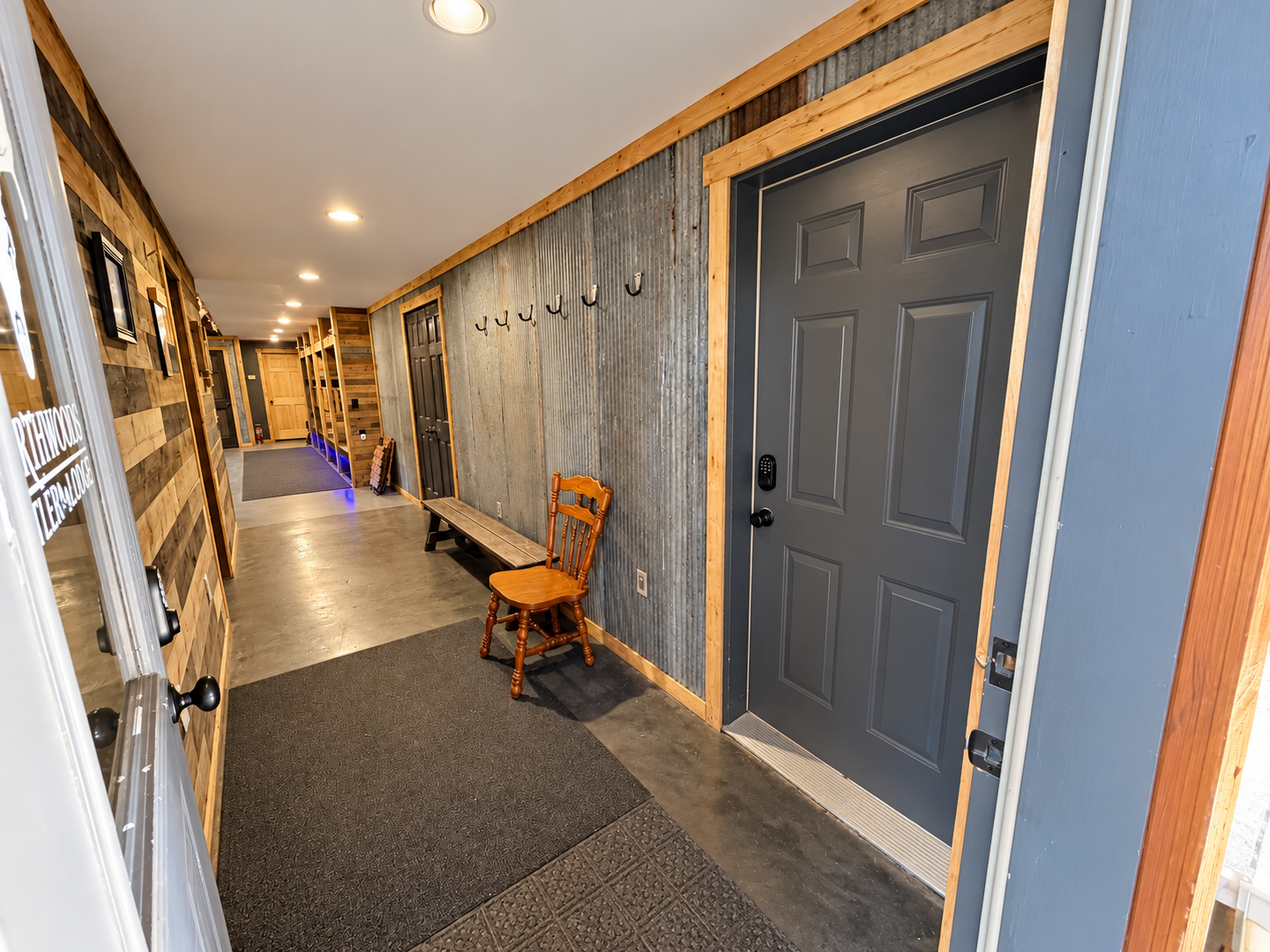 Step inside to a secure smart-lock entrance leading into the lodge living area, with a long interior hallway providing convenient access through to the attached garage.