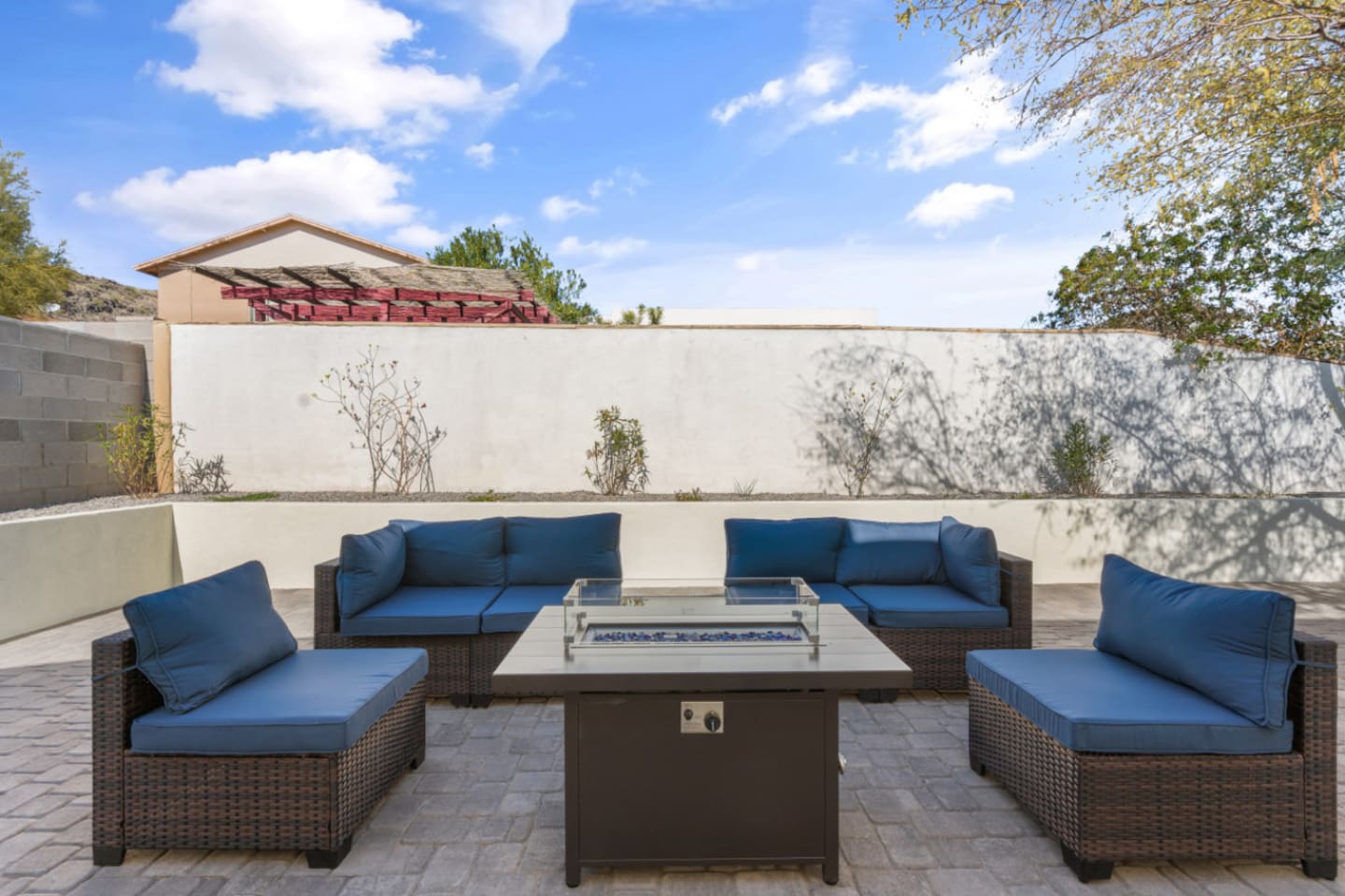 Outdoor living space with comfortable seating, grill, and a fire pit table for evening downtime.
