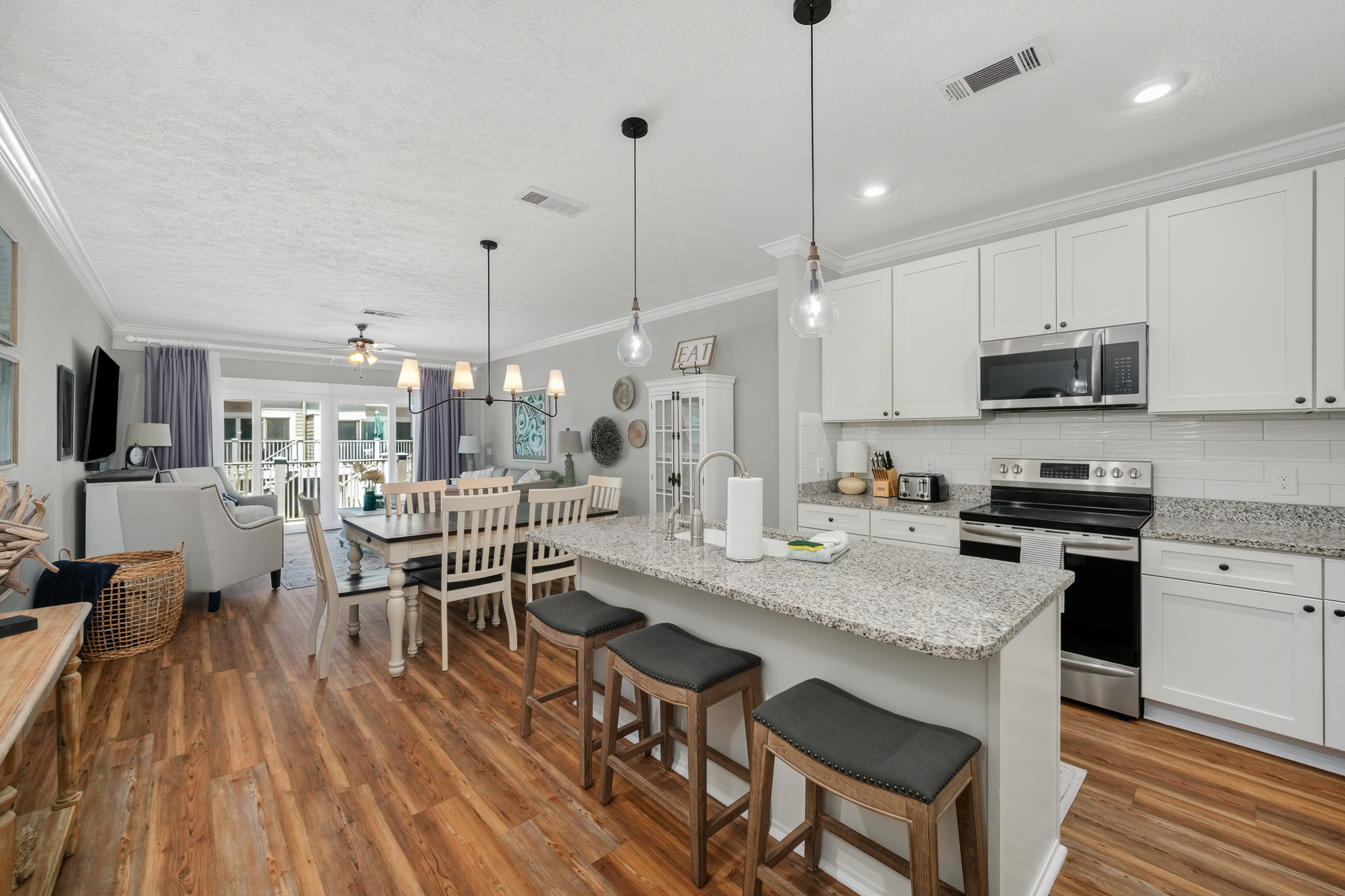 Bright, fully equipped kitchen featuring stainless steel appliances, granite countertops, a large island, and everything needed for a comfortable stay