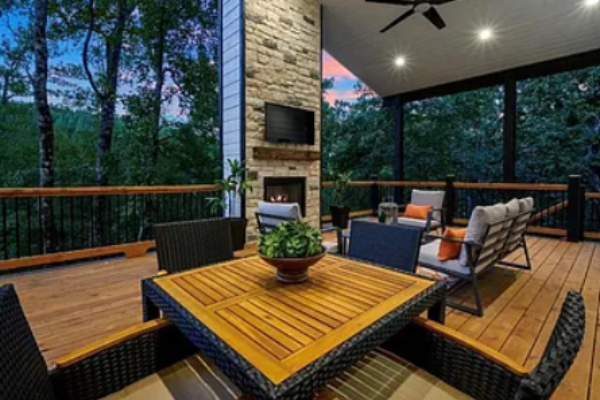 Covered patio with fireplace and dining space for outdoor gatherings.