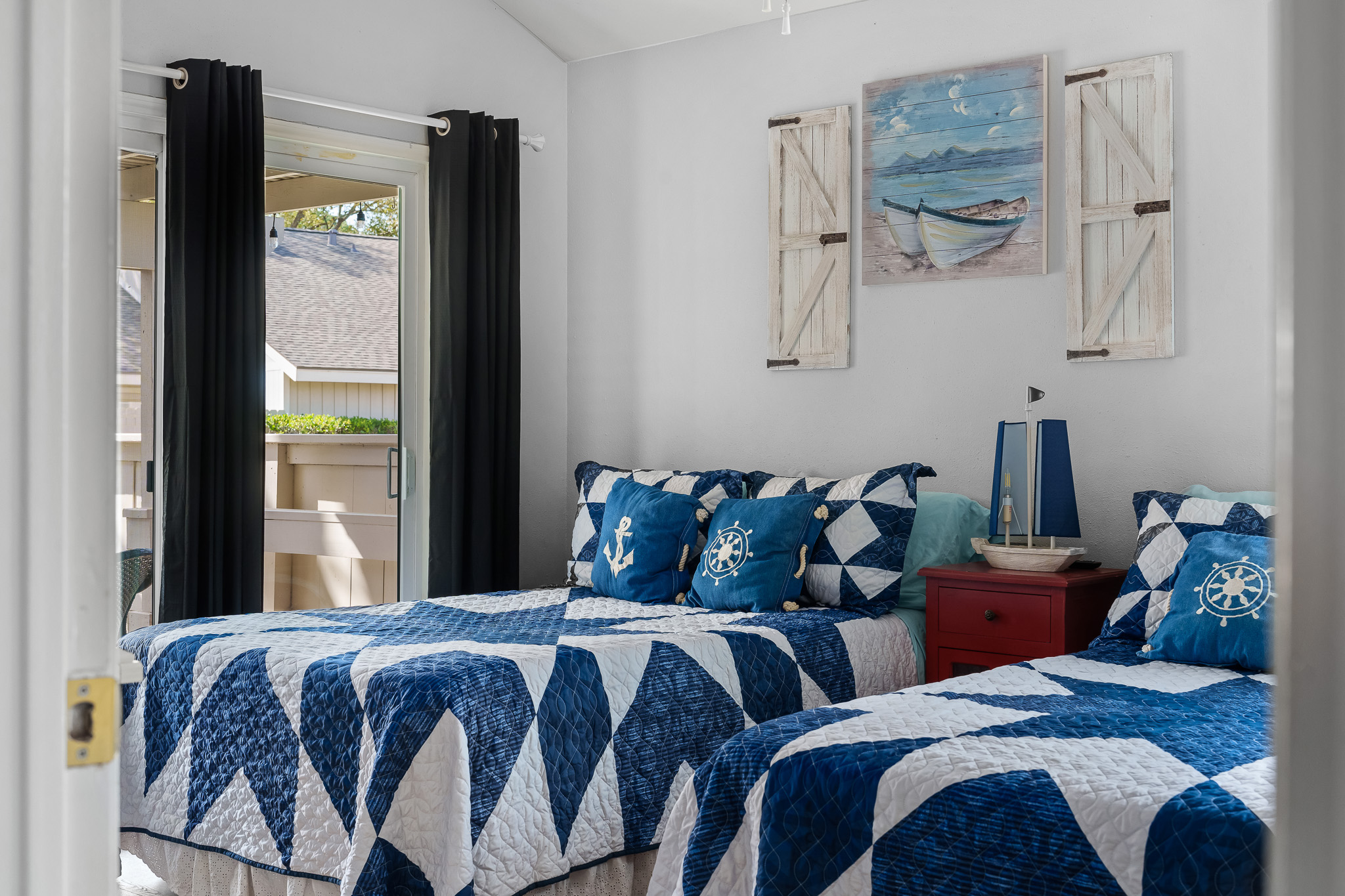 Step into a breezy coastal-inspired guest room with double beds and private patio access—perfect for kids, teens, or friends to relax and recharge after a day at the lake.