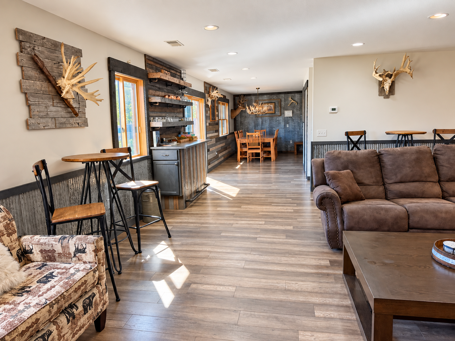 A great view through the lodge’s open gathering spaces, featuring bar-height seating, the dining area, wet bar, and additional seating as you make your way toward the stairs and upper level.