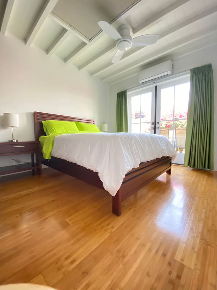 Spacious primary bedroom with a comfortable queen bed and balcony access.