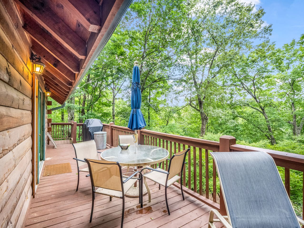 Main level deck with seating area, grill and peaceful woodland scenery