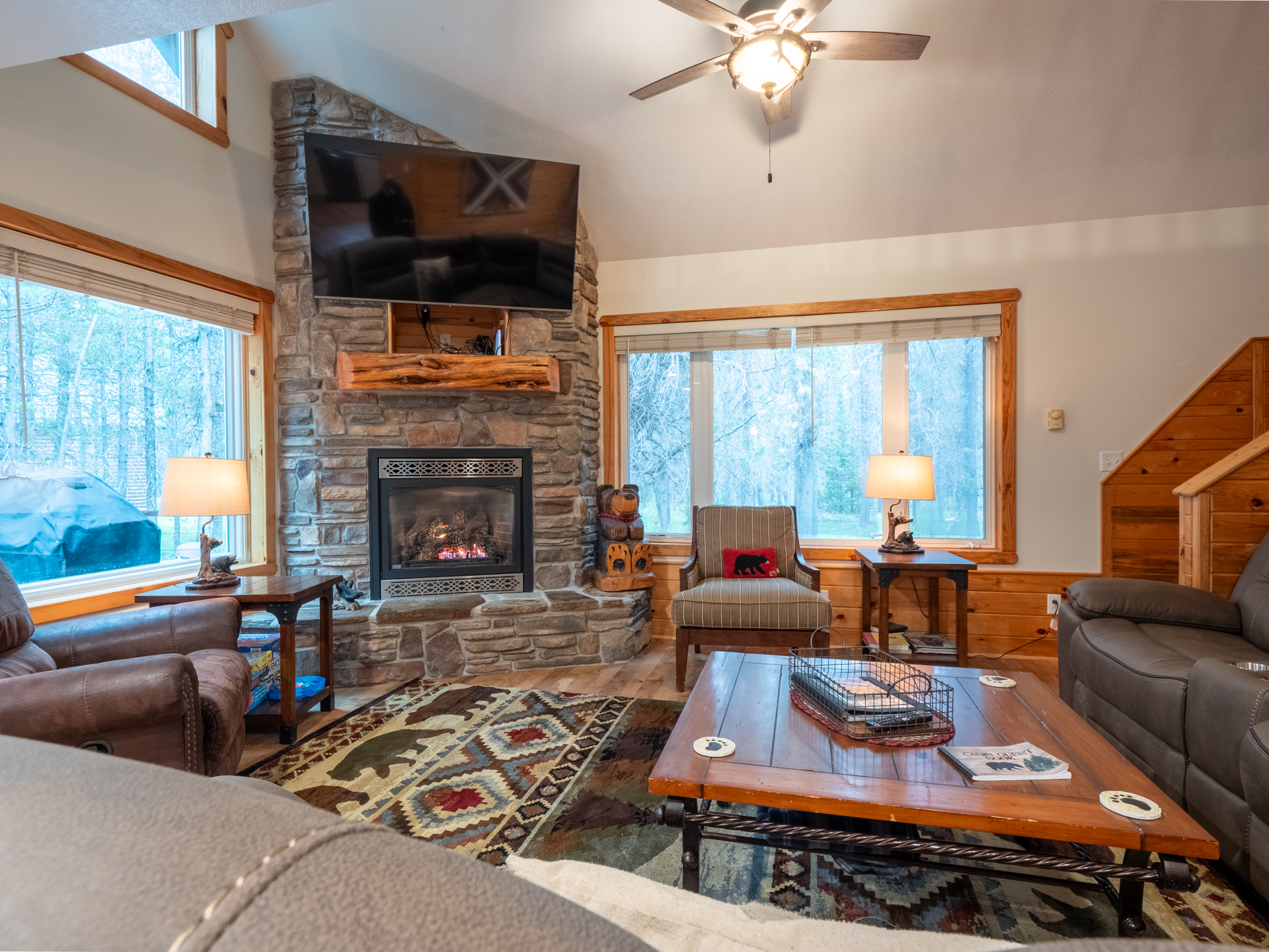 Warmth and a restful fireplace with a view of the trees and stairs to the loft/bedroom, and bedroom 3
