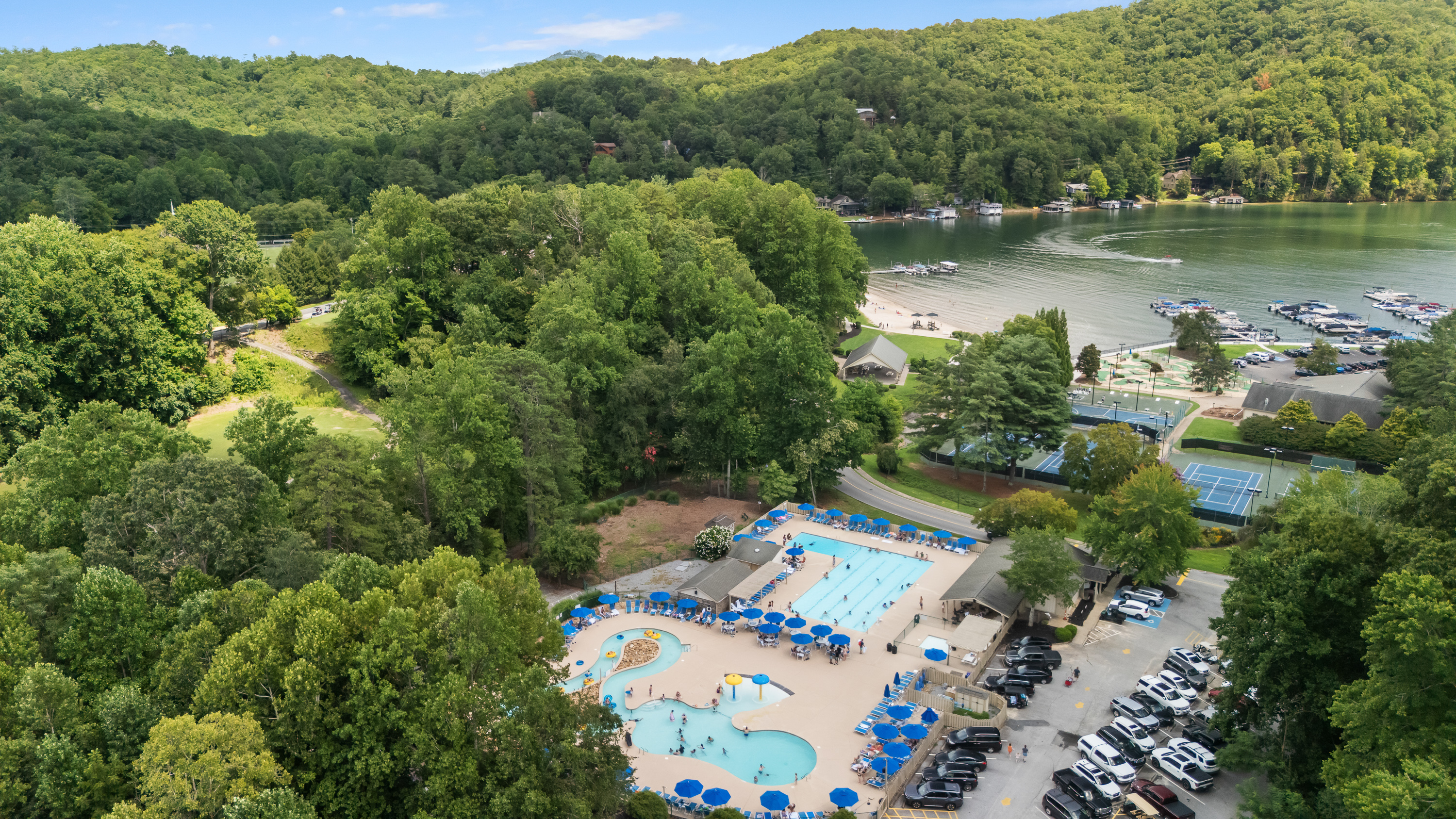 Birds eye view of the pools, courts, and lake.