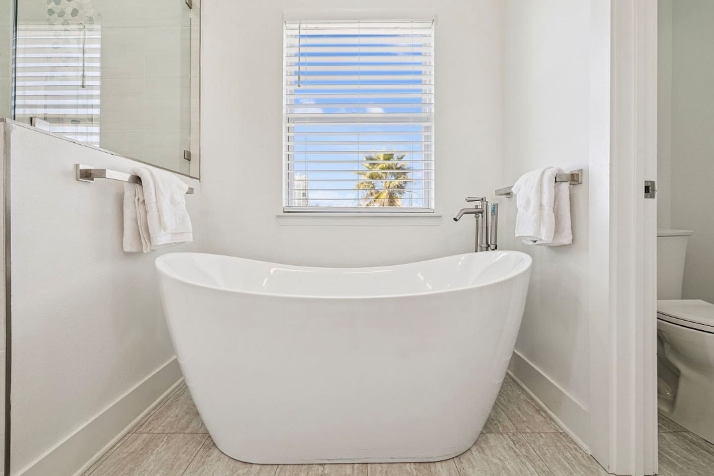Relaxing standalone soaking tub in the primary en-suite bath designed for ultimate unwinding after a beach day
