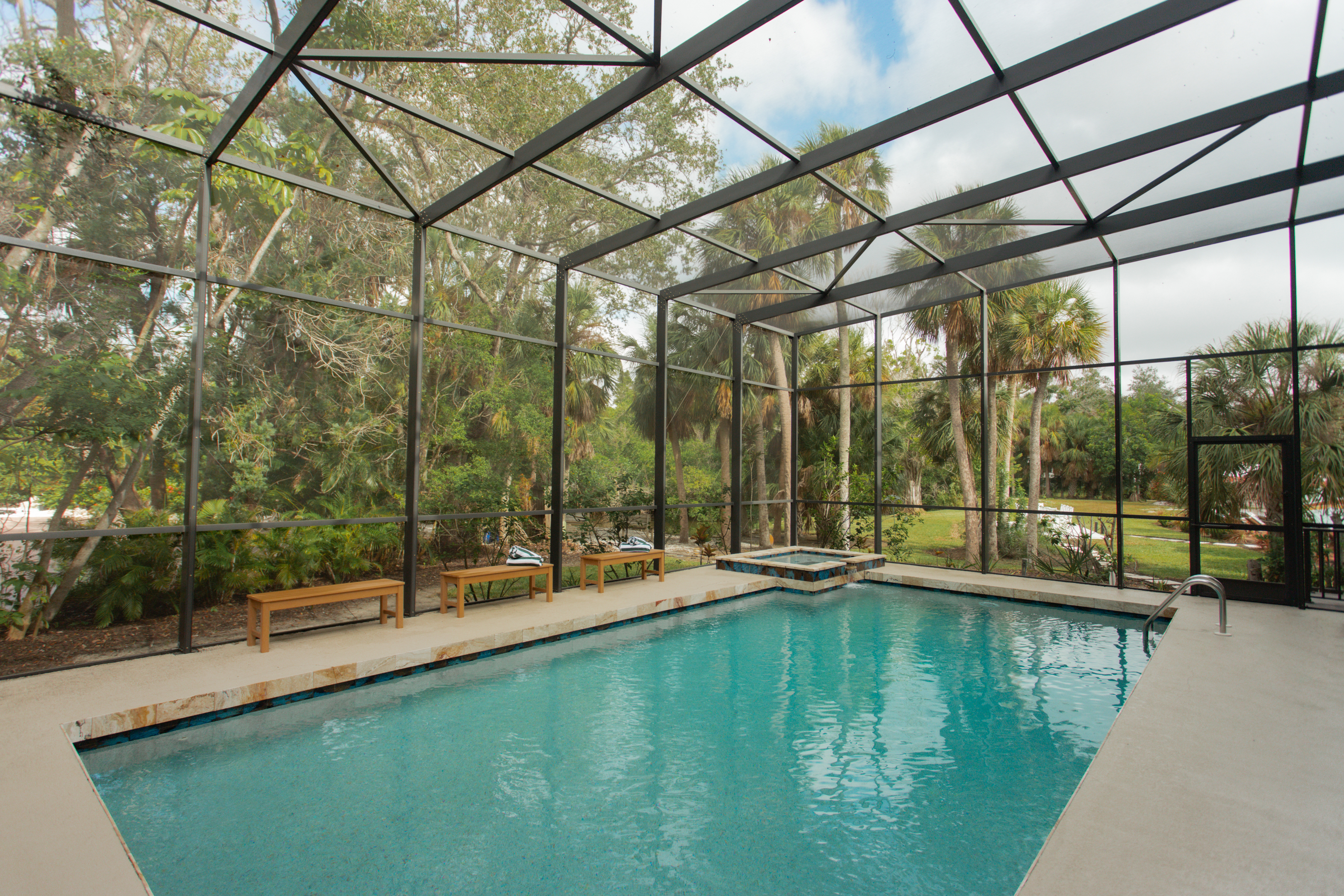 Spacious, screened-in saltwater pool framed by a two-story view and swaying palms. Enjoy shaded swims, tropical breezes, and total comfort with no harsh chlorine—just that clean, calm vibe.