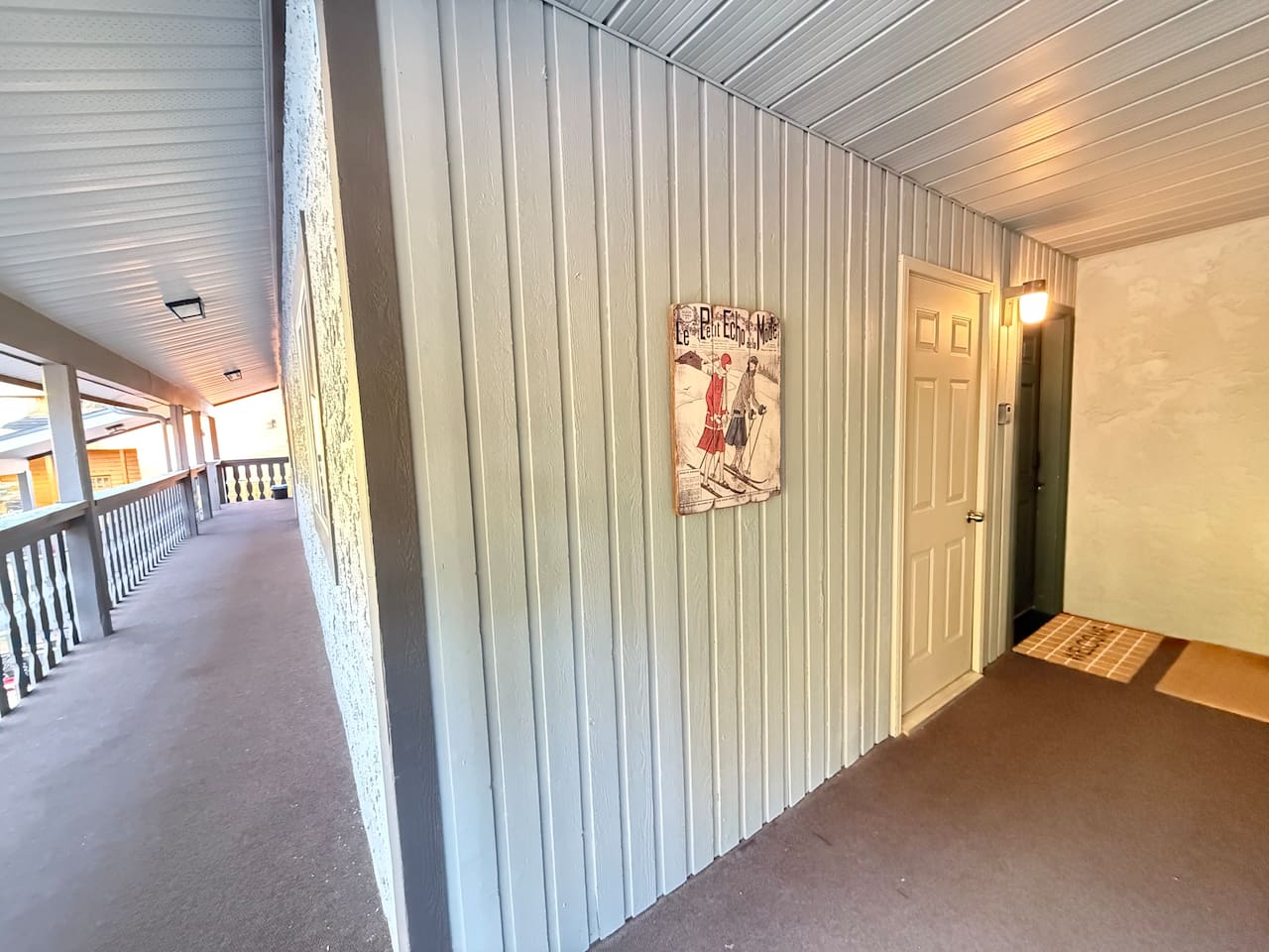 This is the door to the townhouse. The welcome mat is set in front and has a sign that says Suite Stays 855 on the blue door.