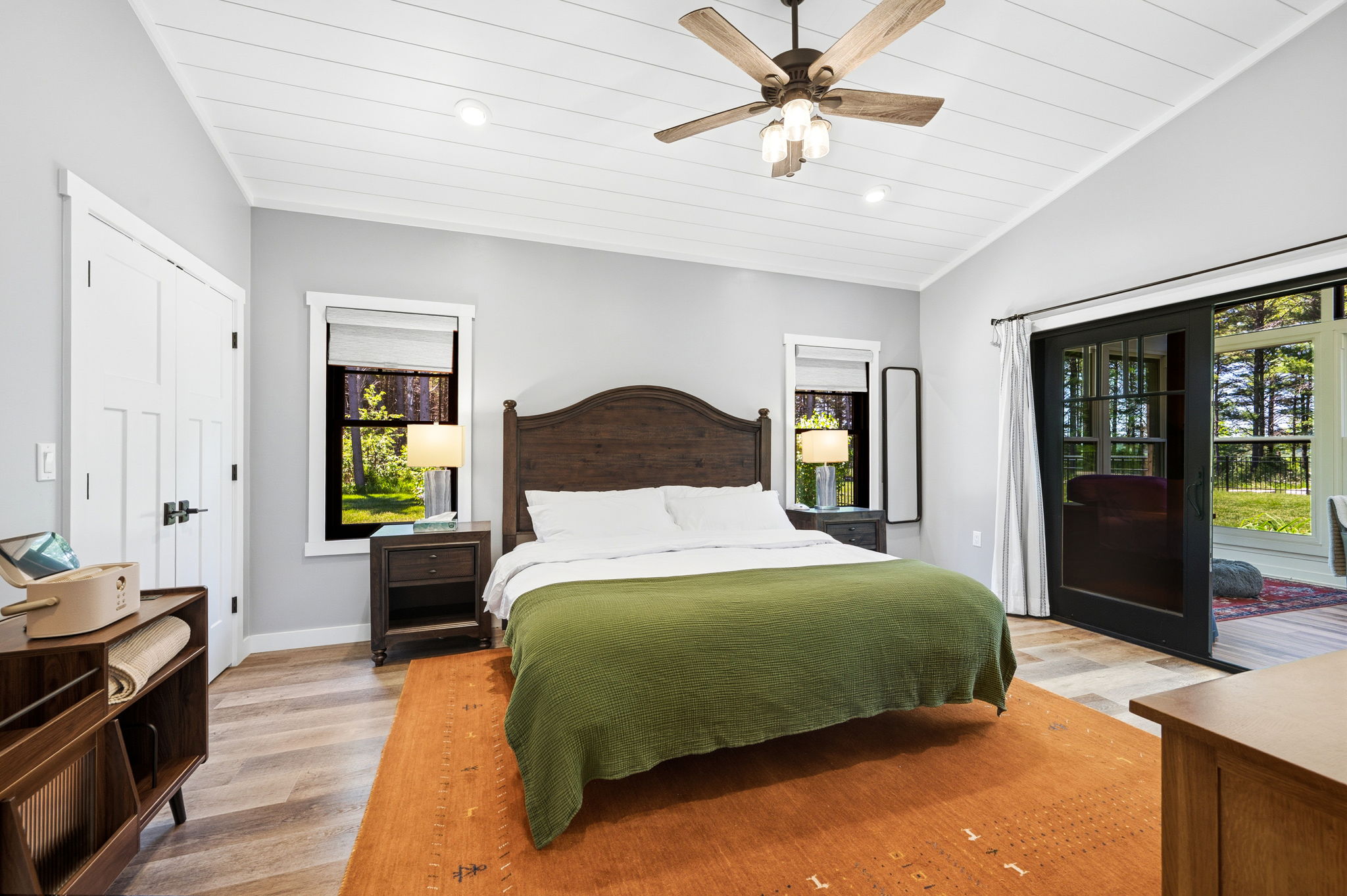 Wake up rested in this serene king bedroom, where soft linens, bedside lamps, and a sliding door to the sunroom create a peaceful escape.