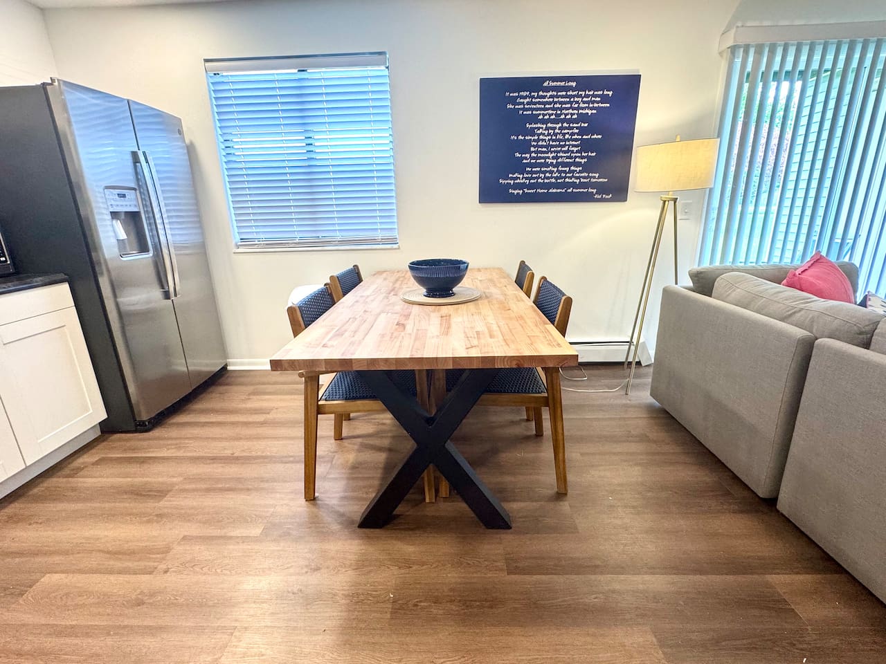 Modern kitchen with stainless steel appliances, open shelving, and a large butcher block dining table. Fully equipped for cooking, dining, and gathering. Bright, stylish, and functional—perfect for shared meals and memories
