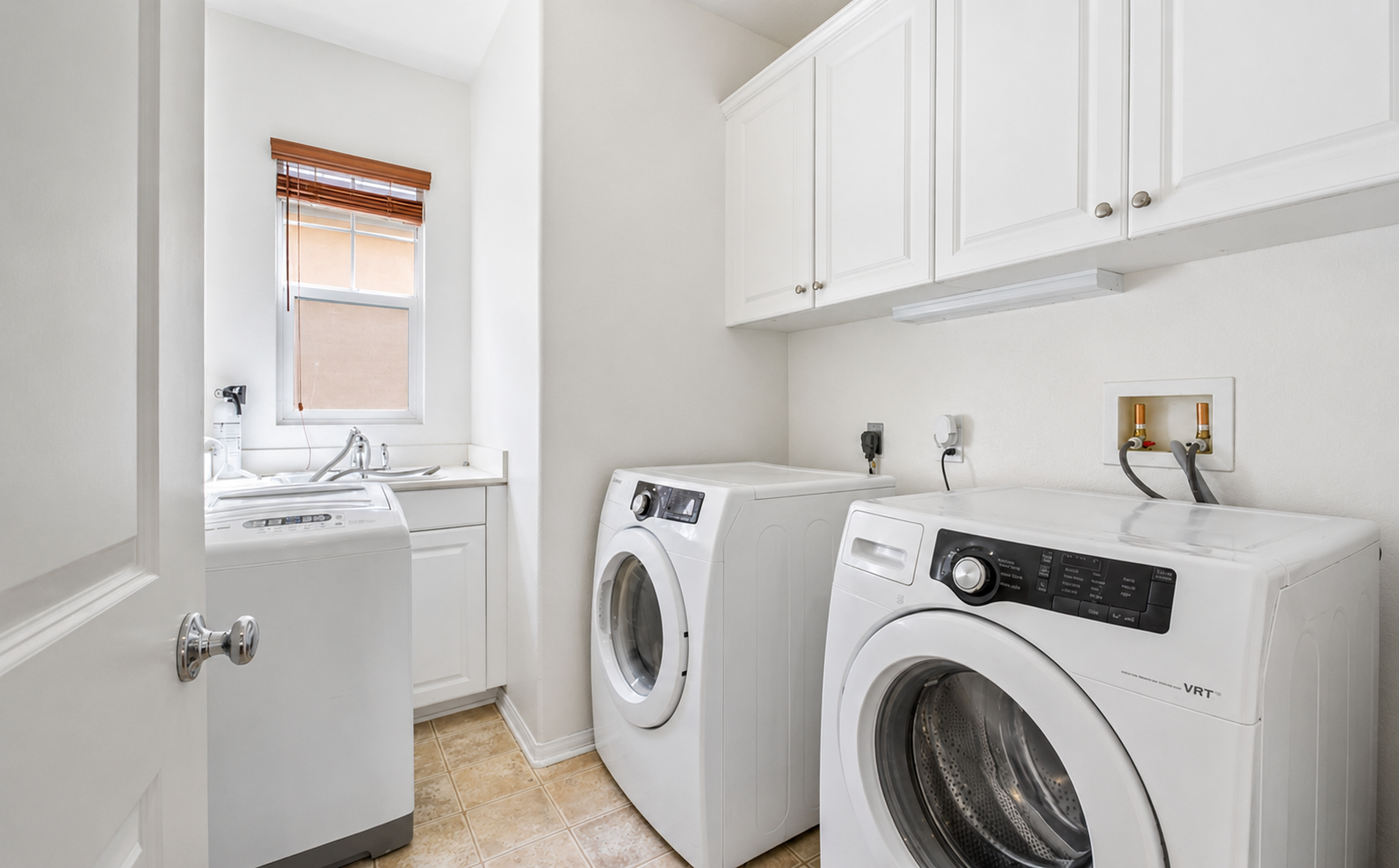 Laundry room with washer, dryer, sink, and cabinet storage for easy longer stays.