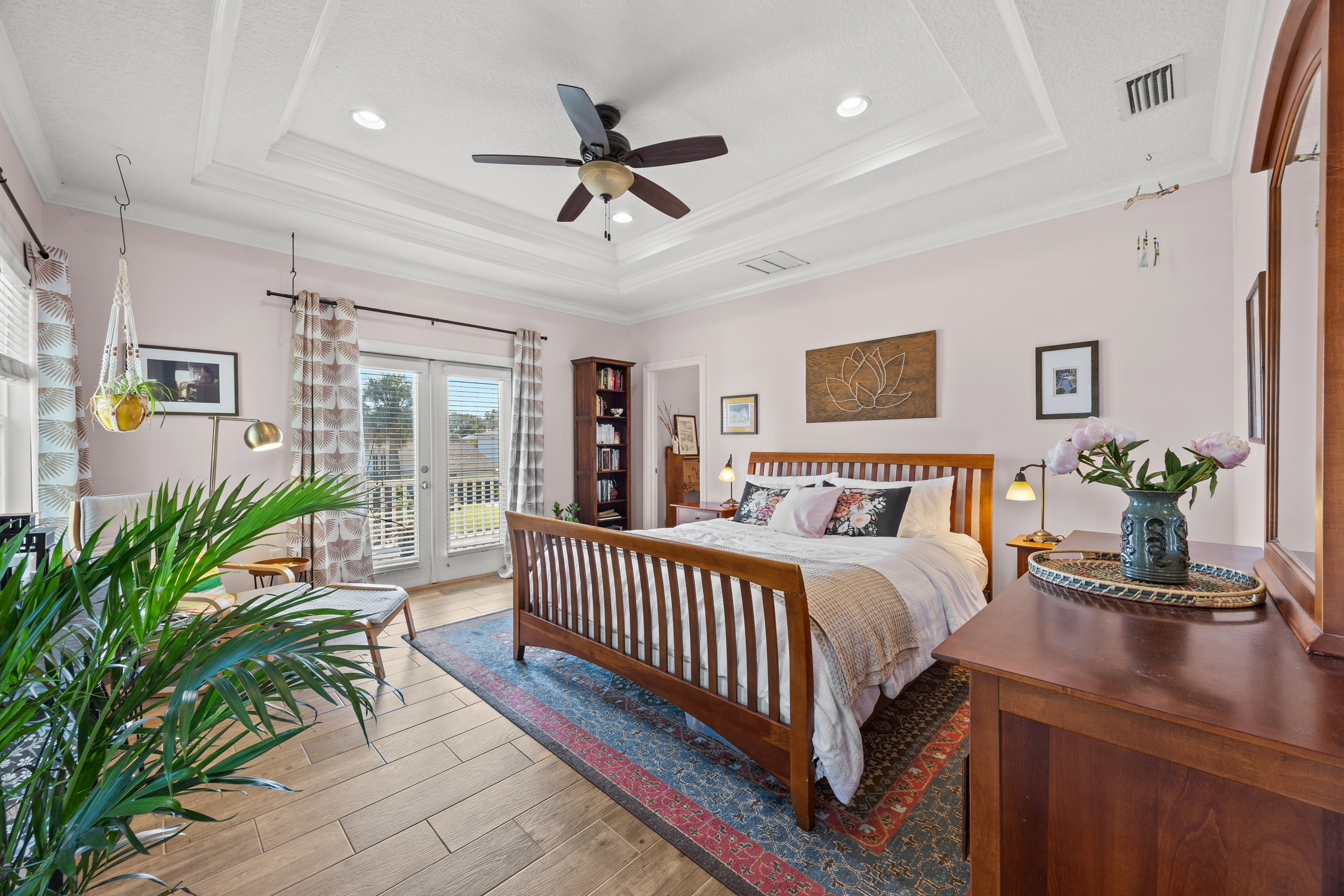 A spacious and modern primary bedroom filled with plenty of natural light and a breezy balcony.