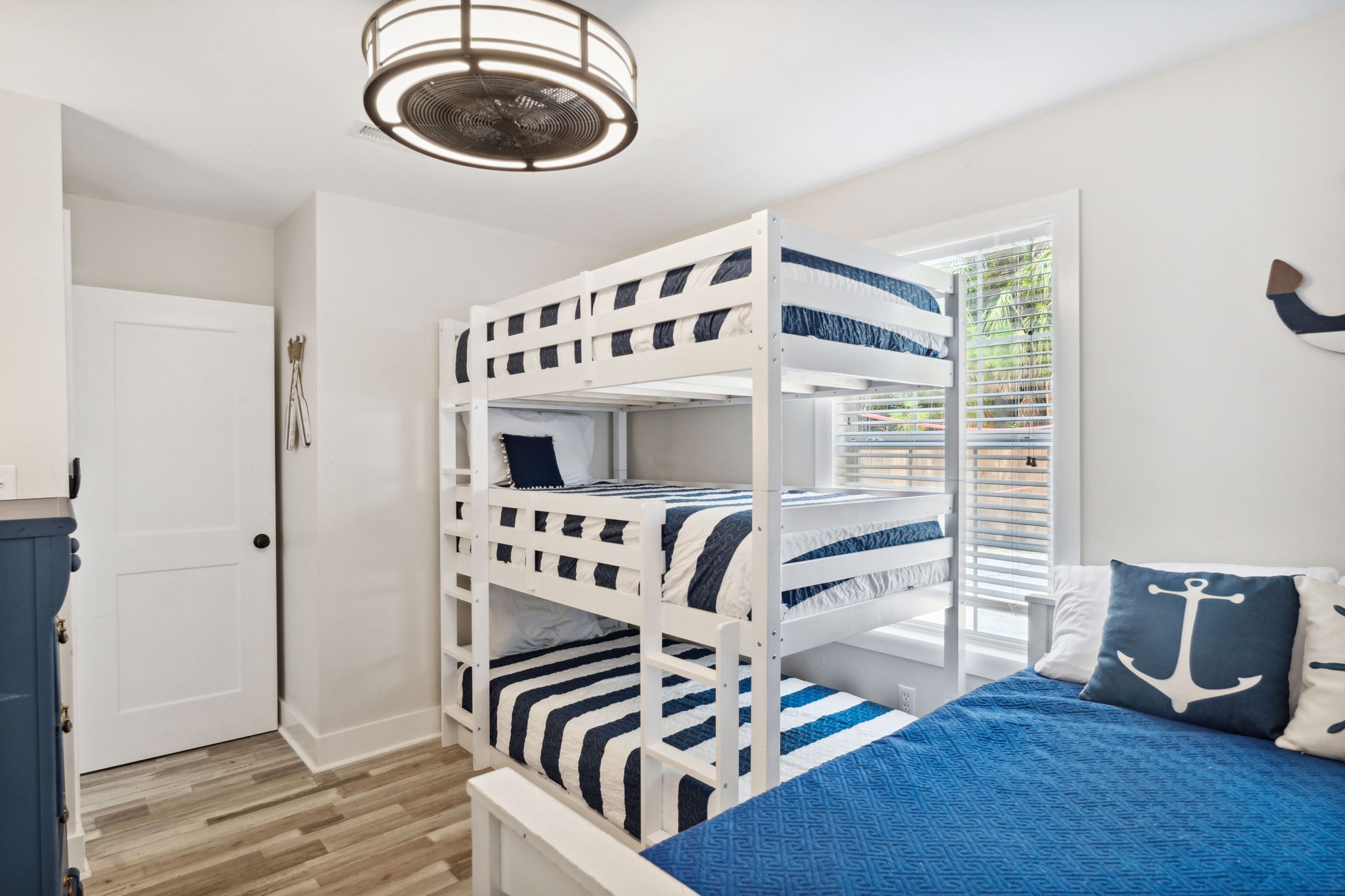 This beach house guest room with triple bunks and full size bed ensures everyone gets a good night's rest. #bunkroom