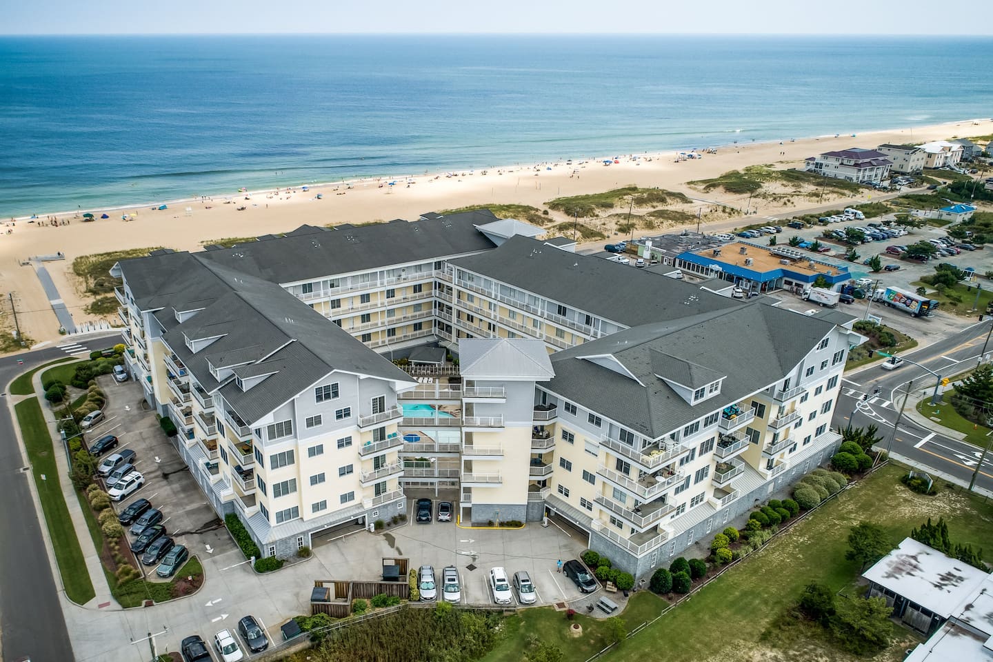 Stunning aerial views of your perfect beach getaway – steps from the sand, balconies overlooking the Atlantic, and a sparkling courtyard pool awaits! ‍♂️