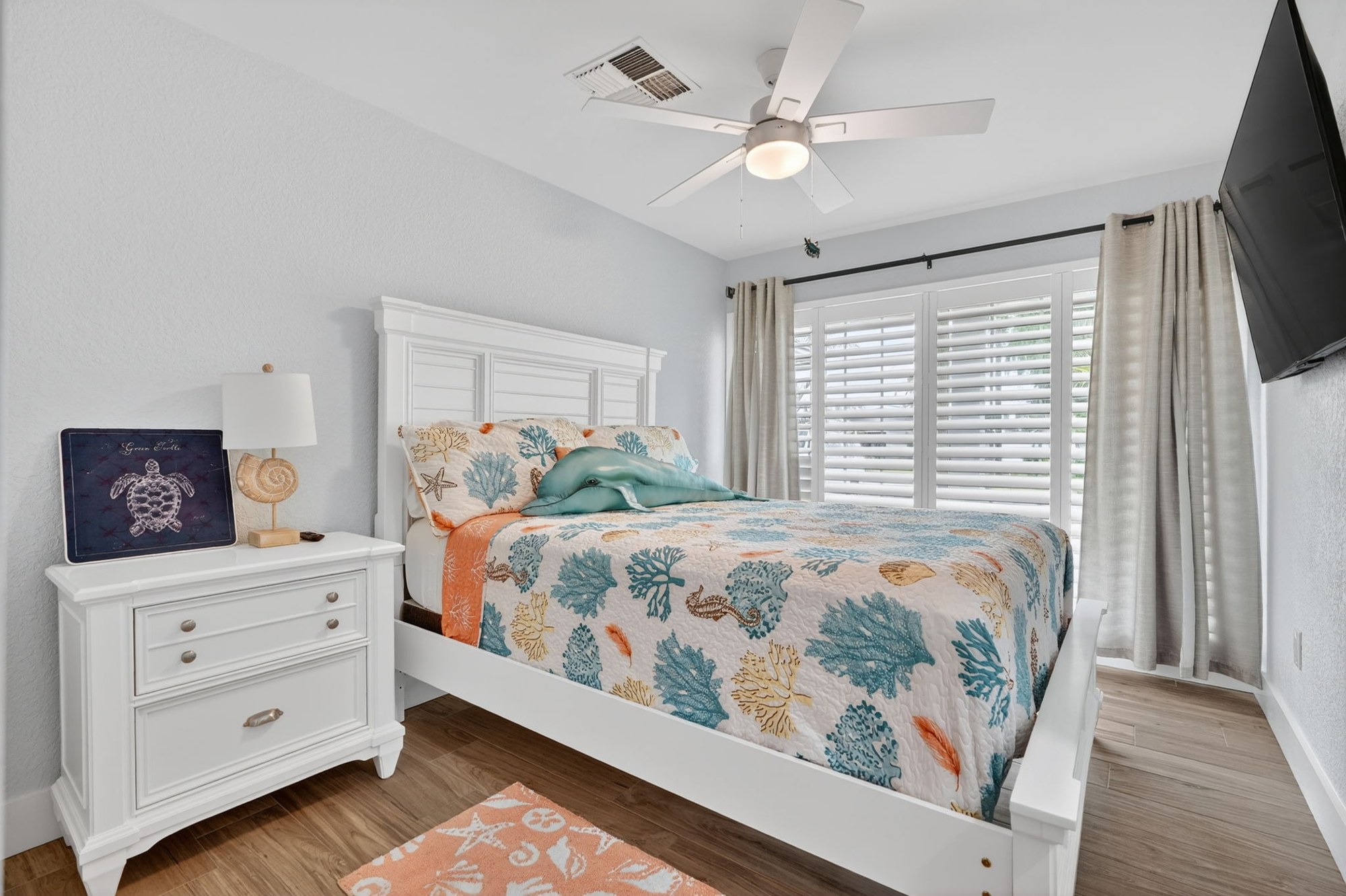 Bedroom with coastal-themed decor and TV