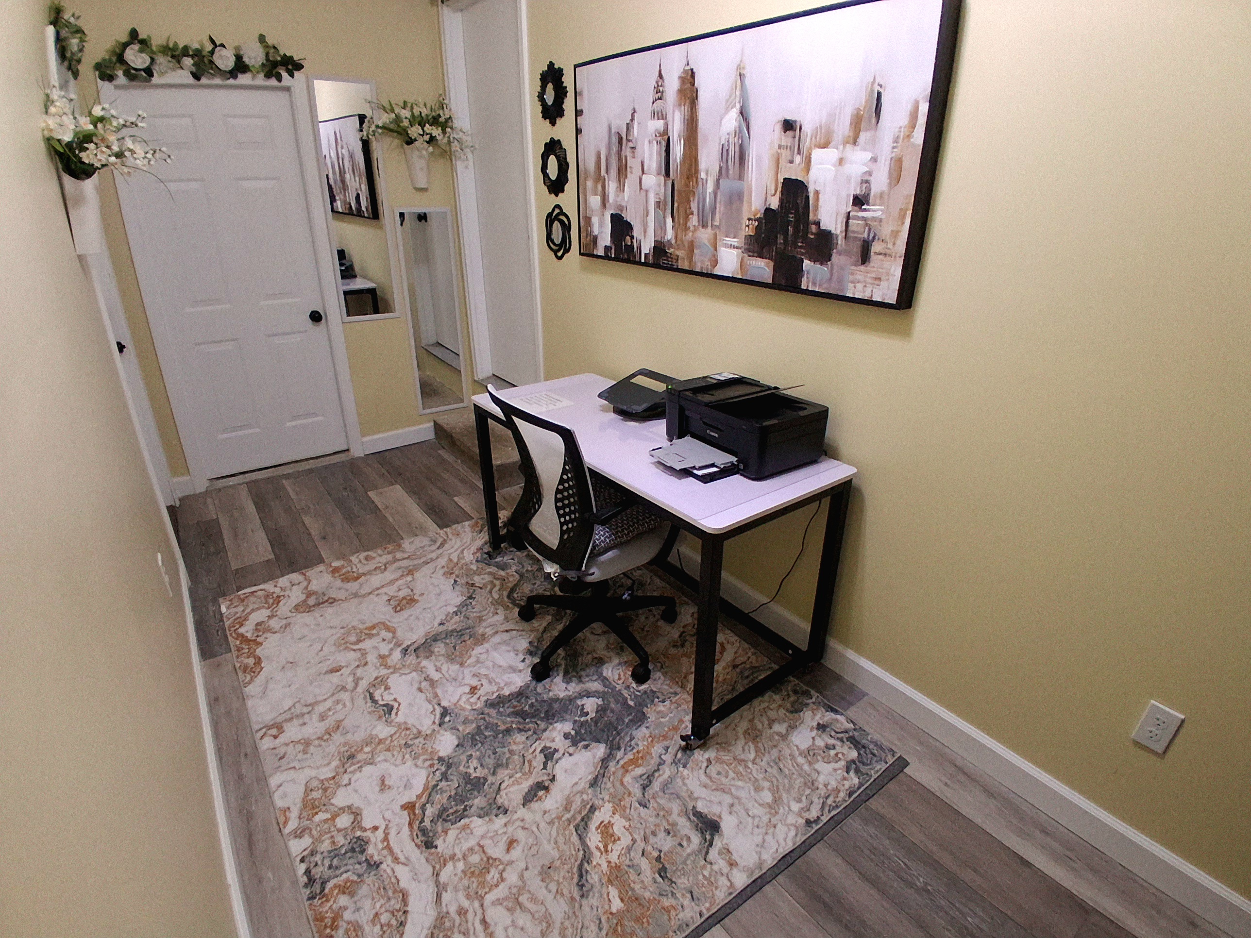 This private, lockable office doubles as a bedroom. The lightweight, wheeled desk easily rolls in front of the laundry room door to clear space for a full-size floor mattress on the rug. Linens, pillows, and a mattress cover are provided.